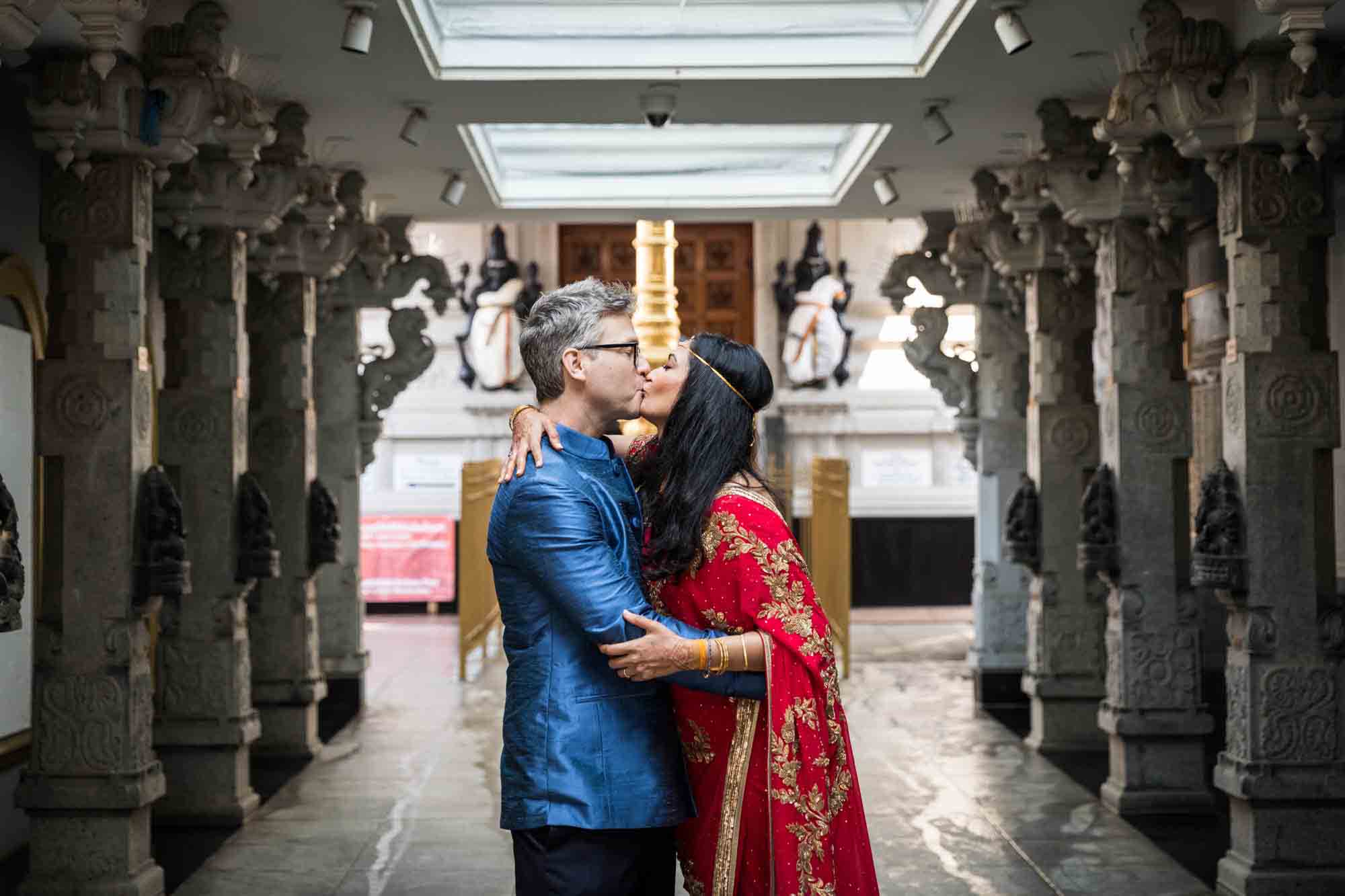 Ganesha Temple wedding photos of bride and groom kissing in main walkway