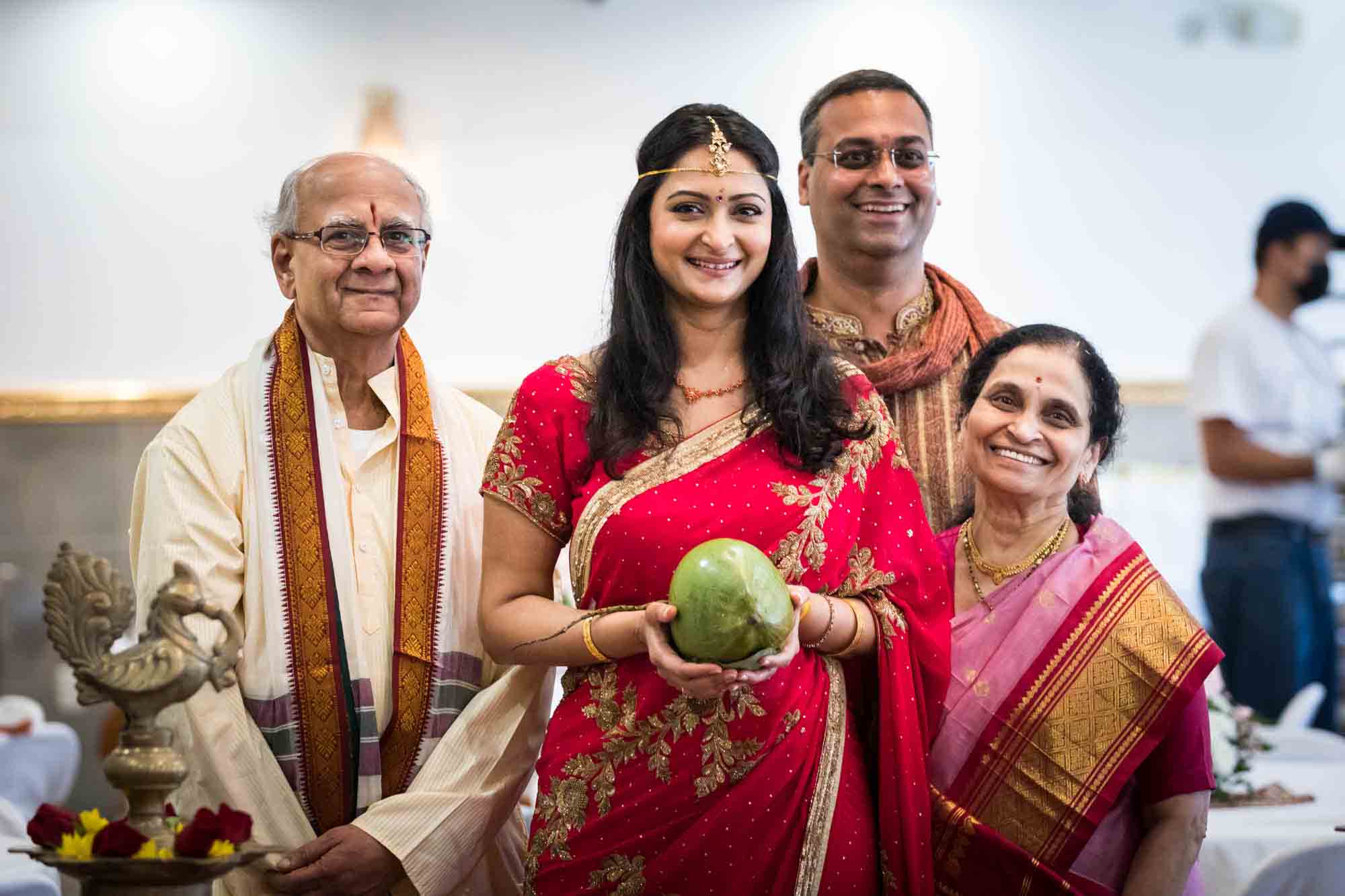 Flushing Temple wedding photos of bride holding coconut and family at end of aisle