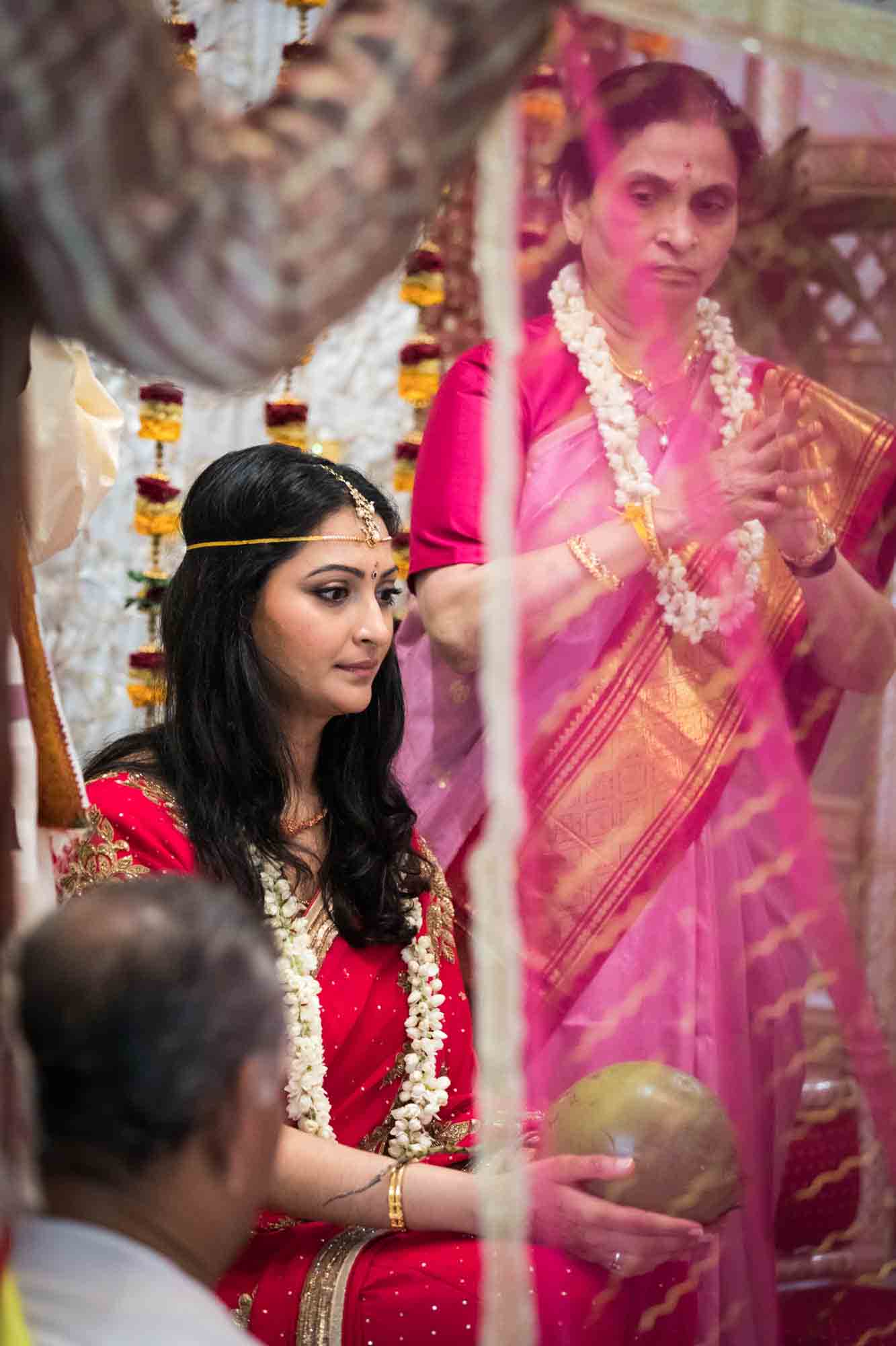 Bride behind pink curtain at a Hindu Temple Society of North America wedding
