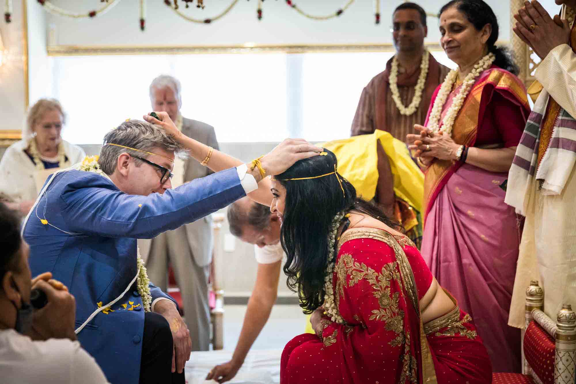 Bride and groom holding rice over their heads at a Hindu Temple Society of North America wedding