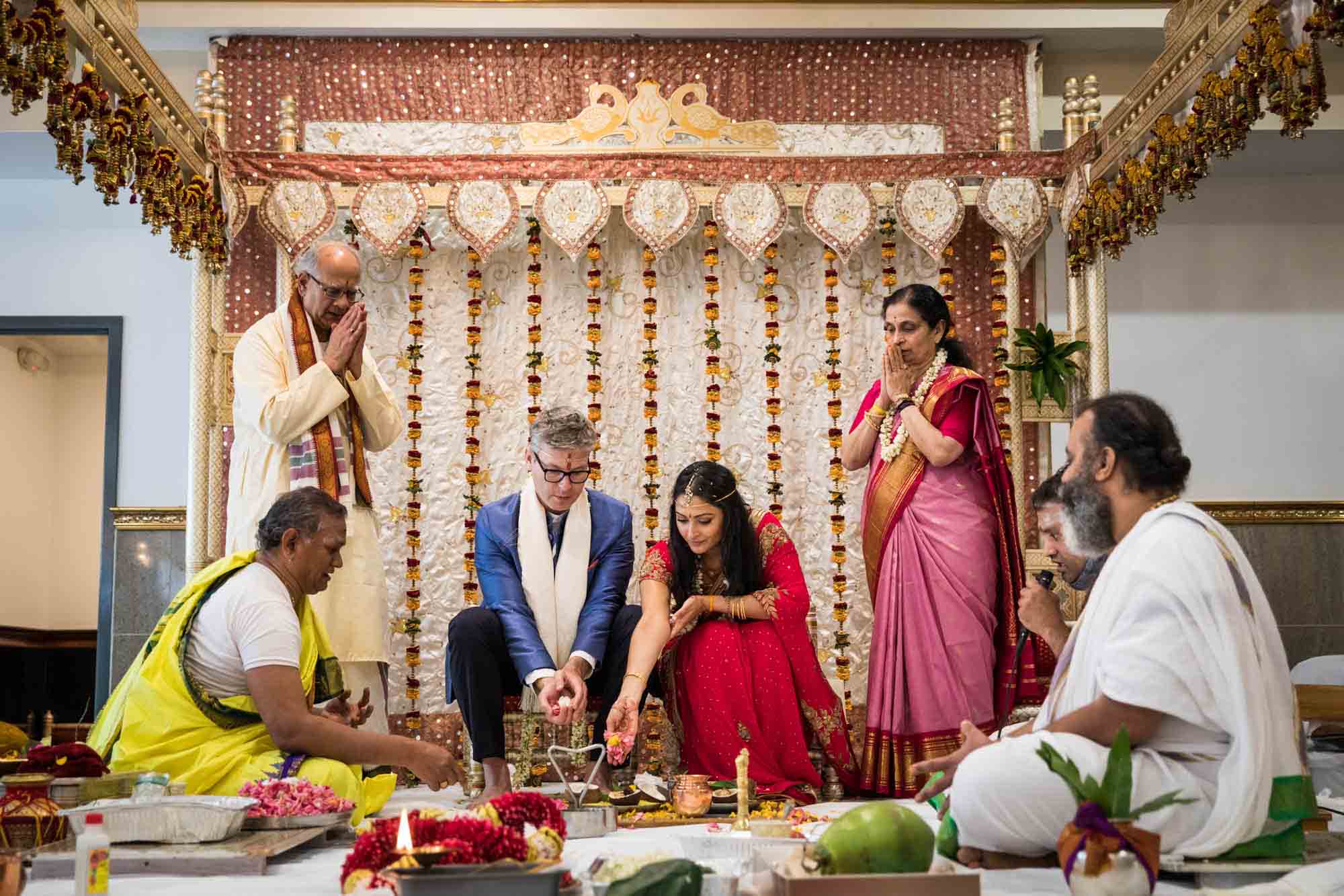 Bride and groom surrounded by family and priests at a Hindu Temple Society of North America wedding