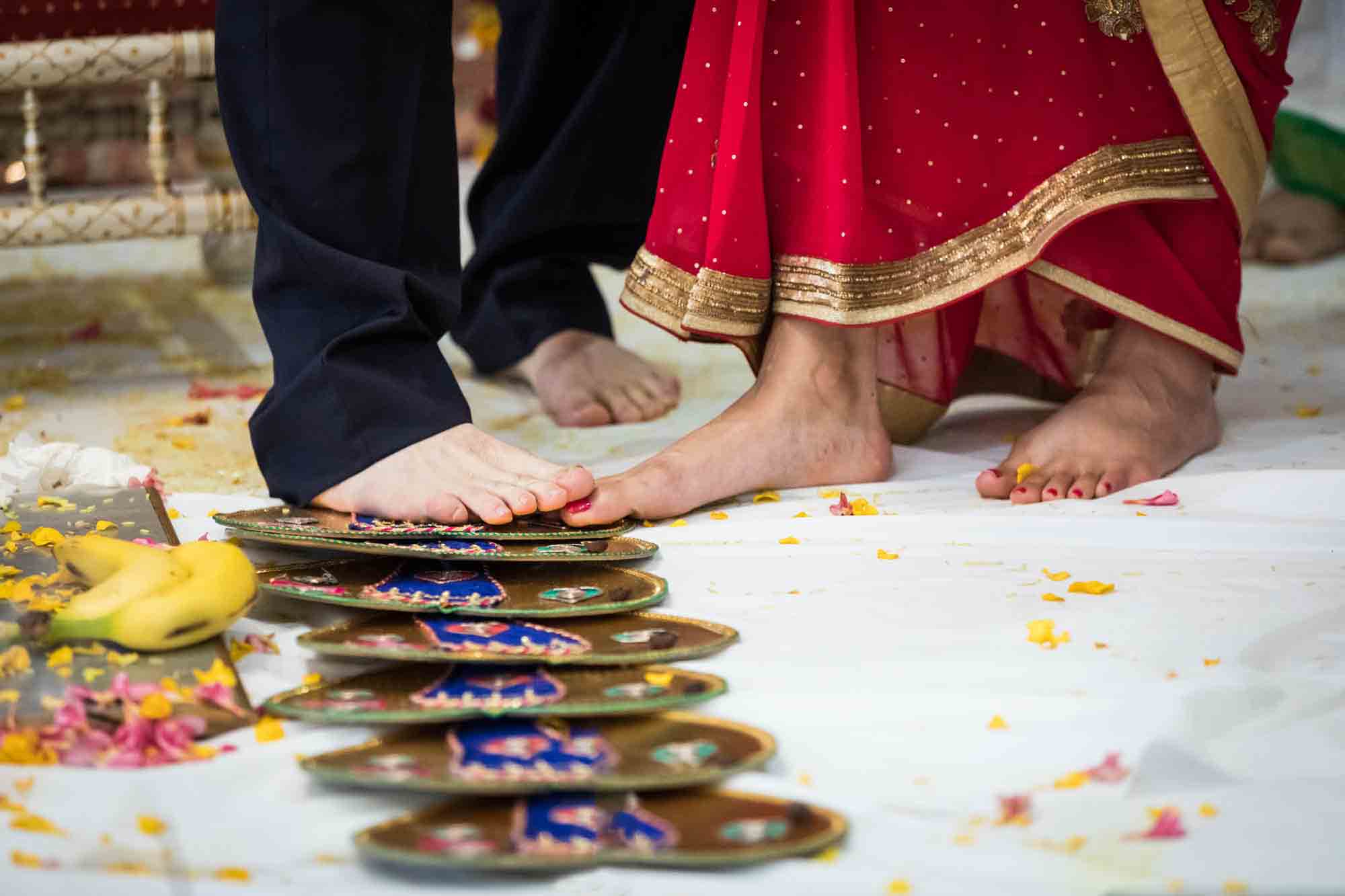 Close up of bride and groom touching feet during Seven Steps at a Ganesha Temple wedding