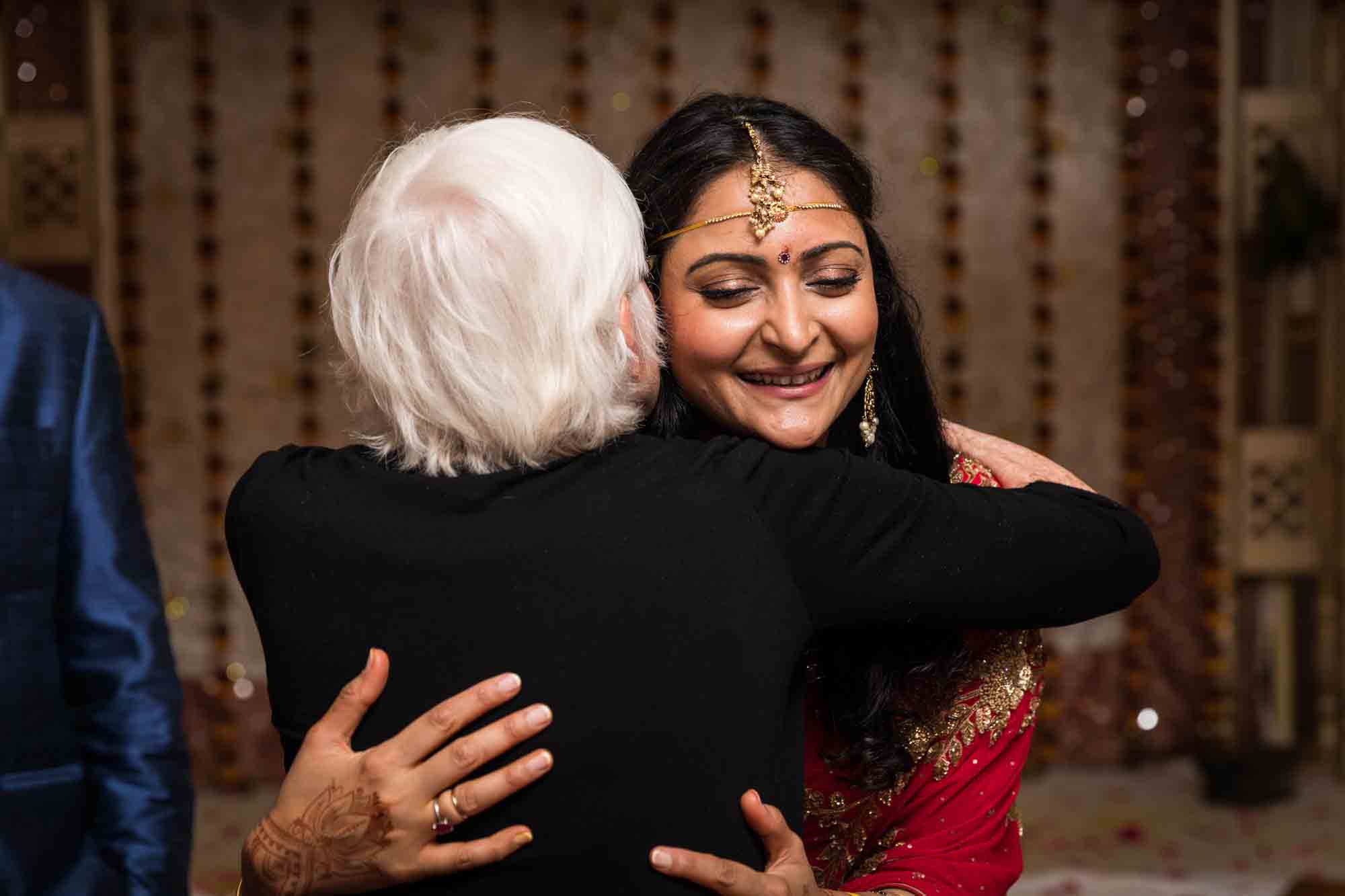 Hindu Temple Society of North America wedding photos of bride hugging woman with white hair