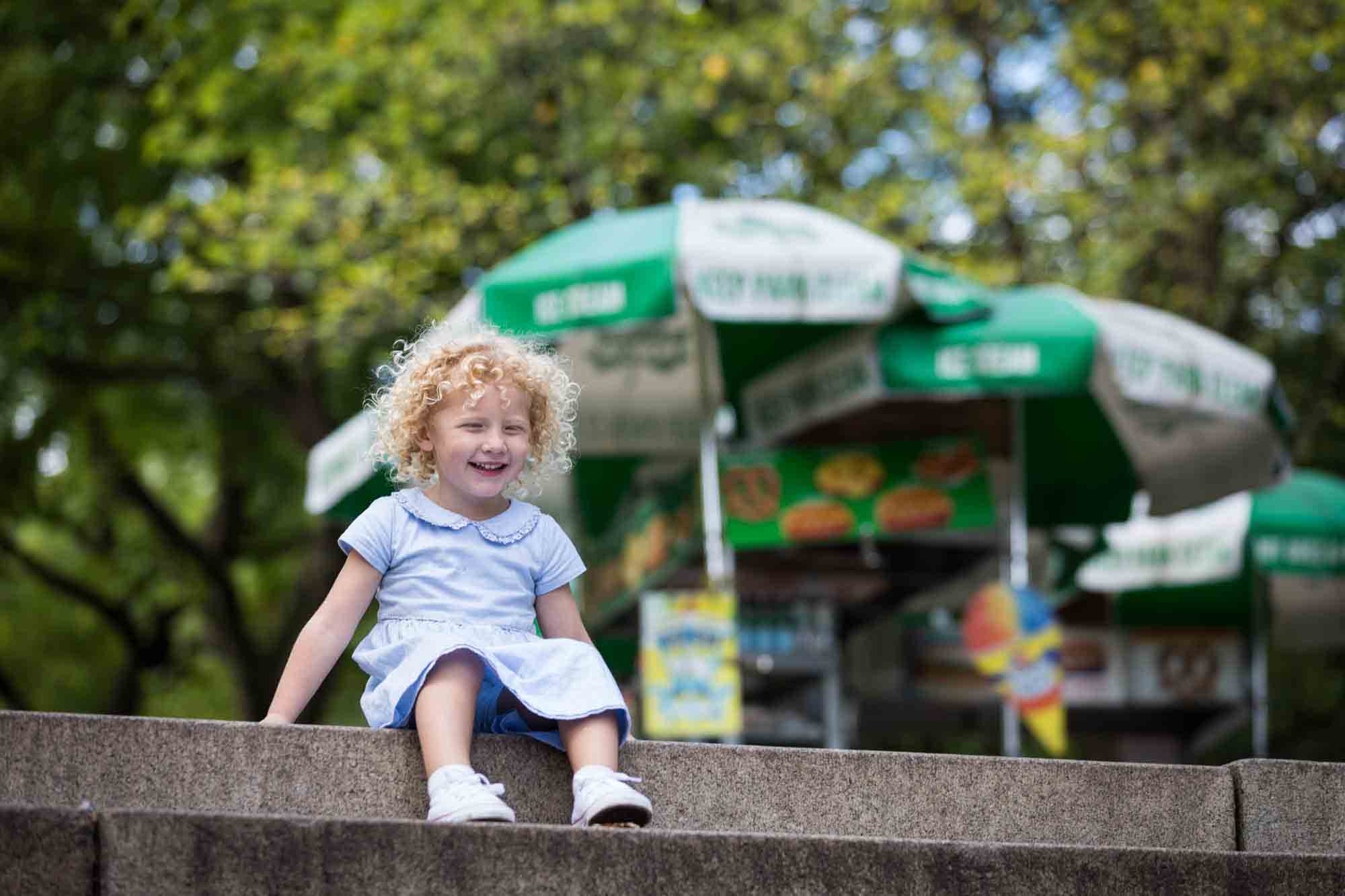 Little girl sitting on steps in Central Park for an article on NYC family portrait tips for tourists