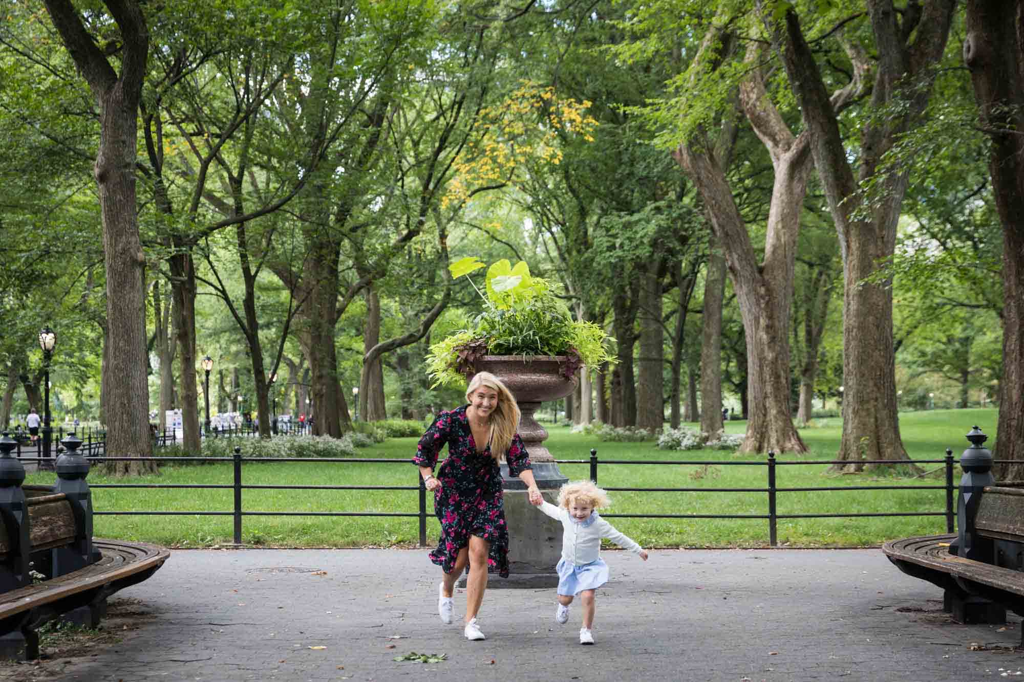 Mother and child running on pathway in Central Park for an article on NYC family portrait tips for tourists