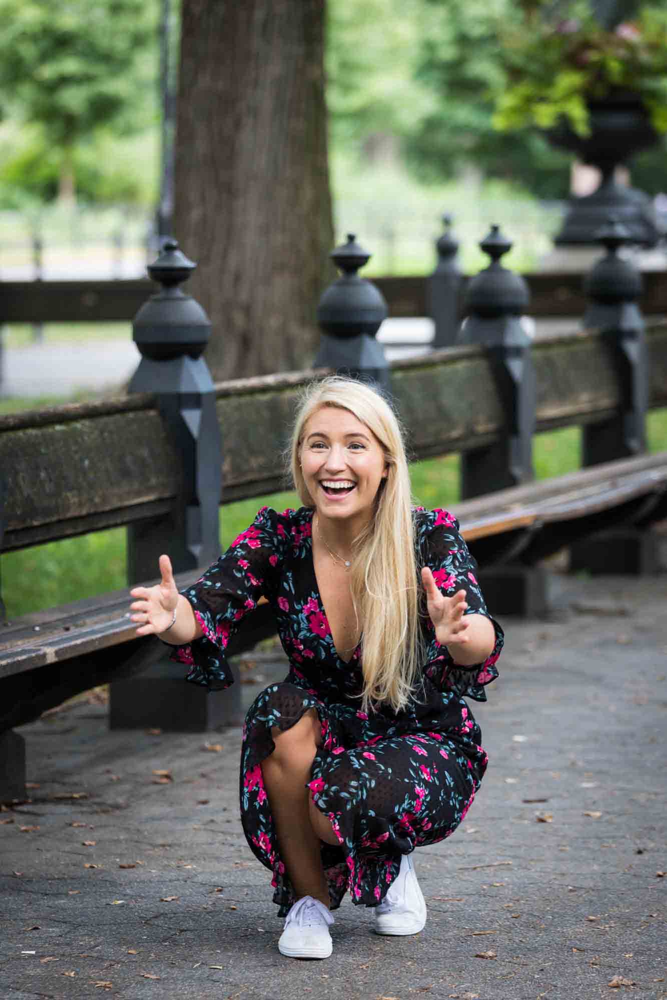 Central Park family portrait of mother crouched down with open arms