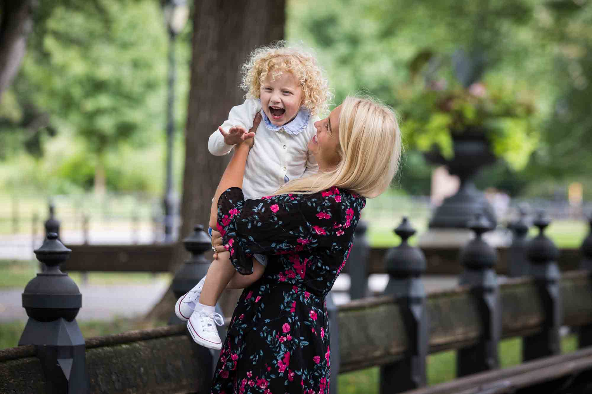 Central Park family portrait of blonde mother holding blonde little girl