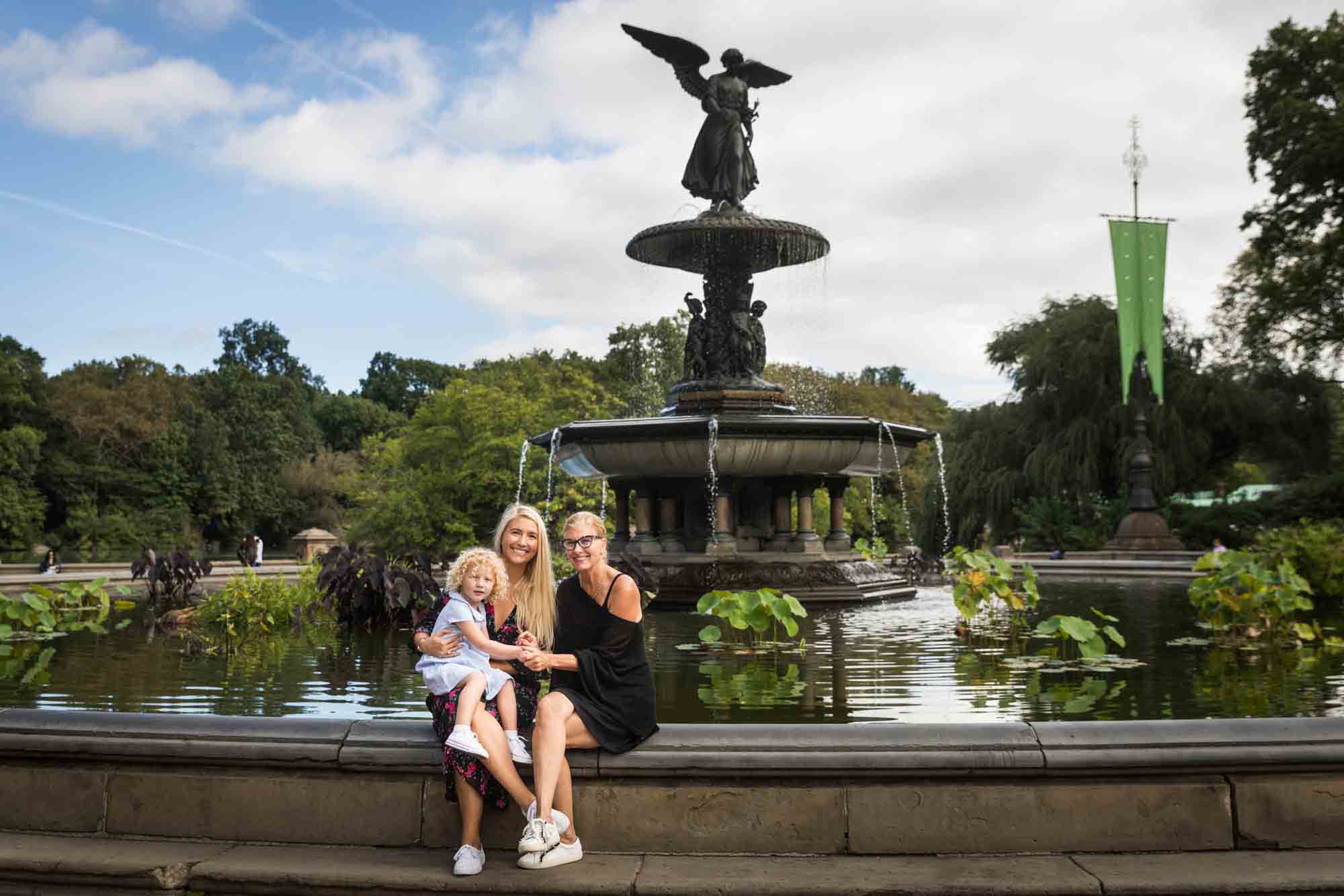 Mother, grandmother, and little girl in front of Bethesda Fountain for an article on NYC family portrait tips for tourists