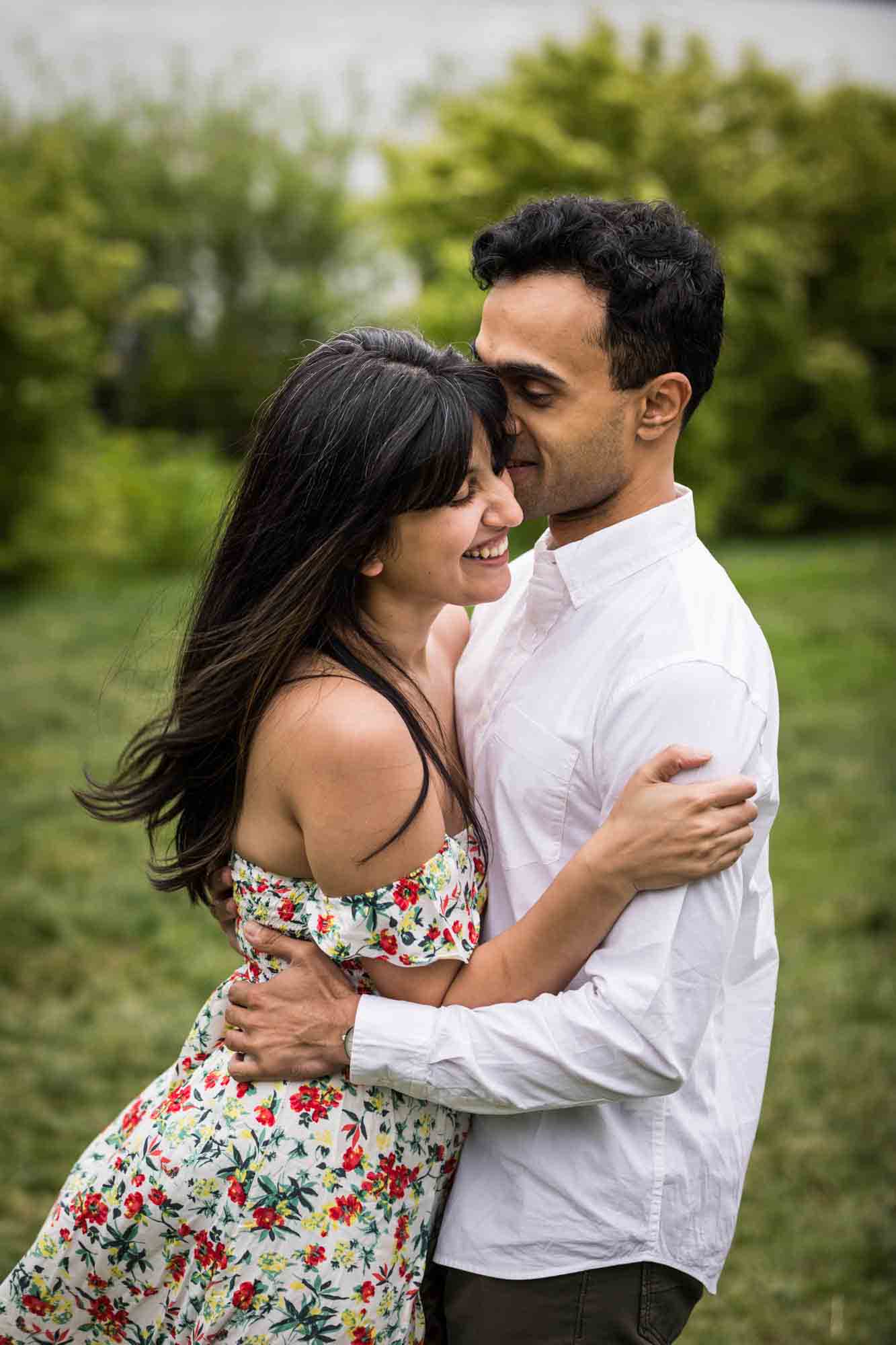 Couple dancing in grass during a Brooklyn Bridge Park engagement photo shoot