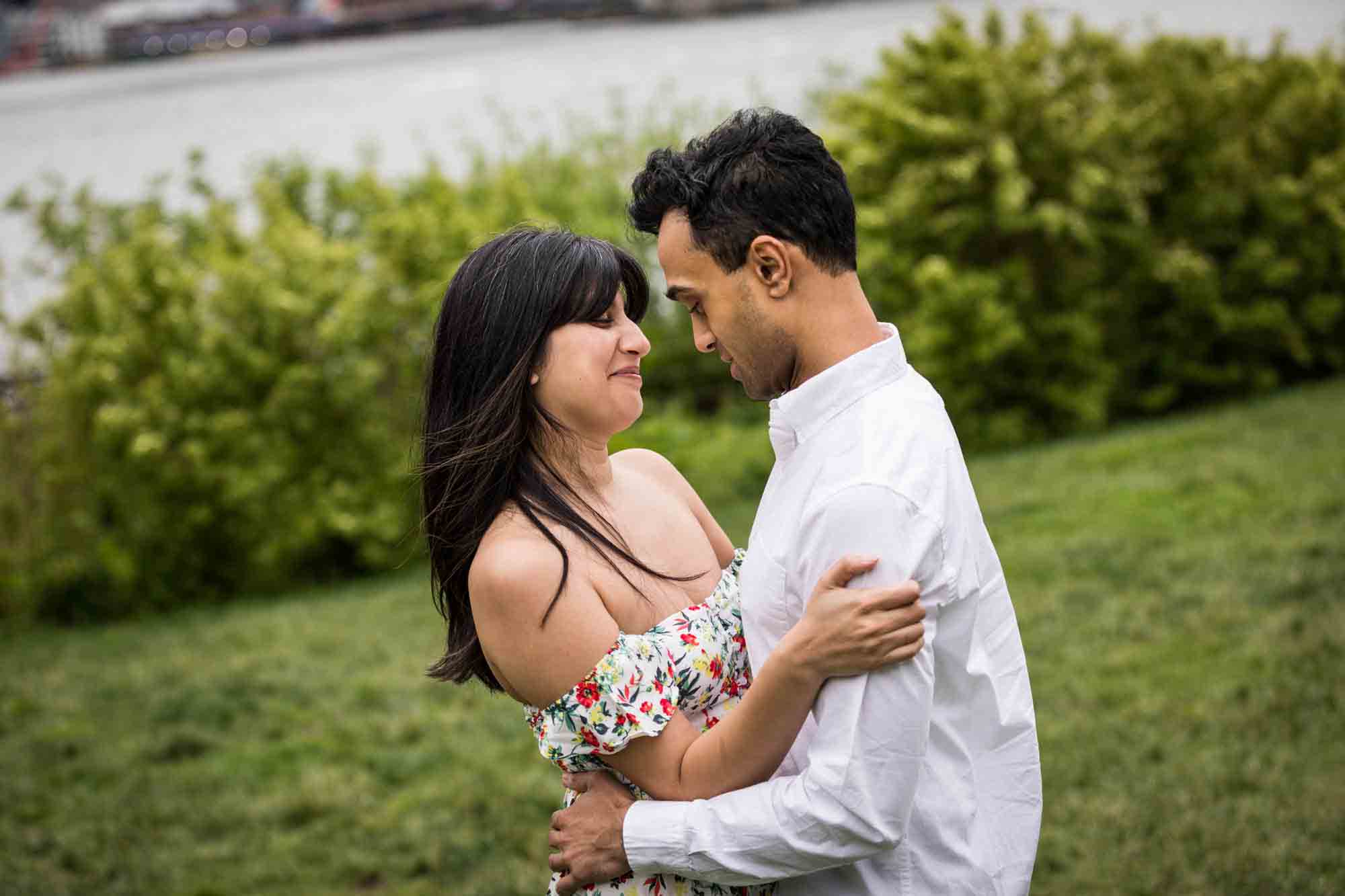 Couple dancing in grass during a Brooklyn Bridge Park engagement photo shoot