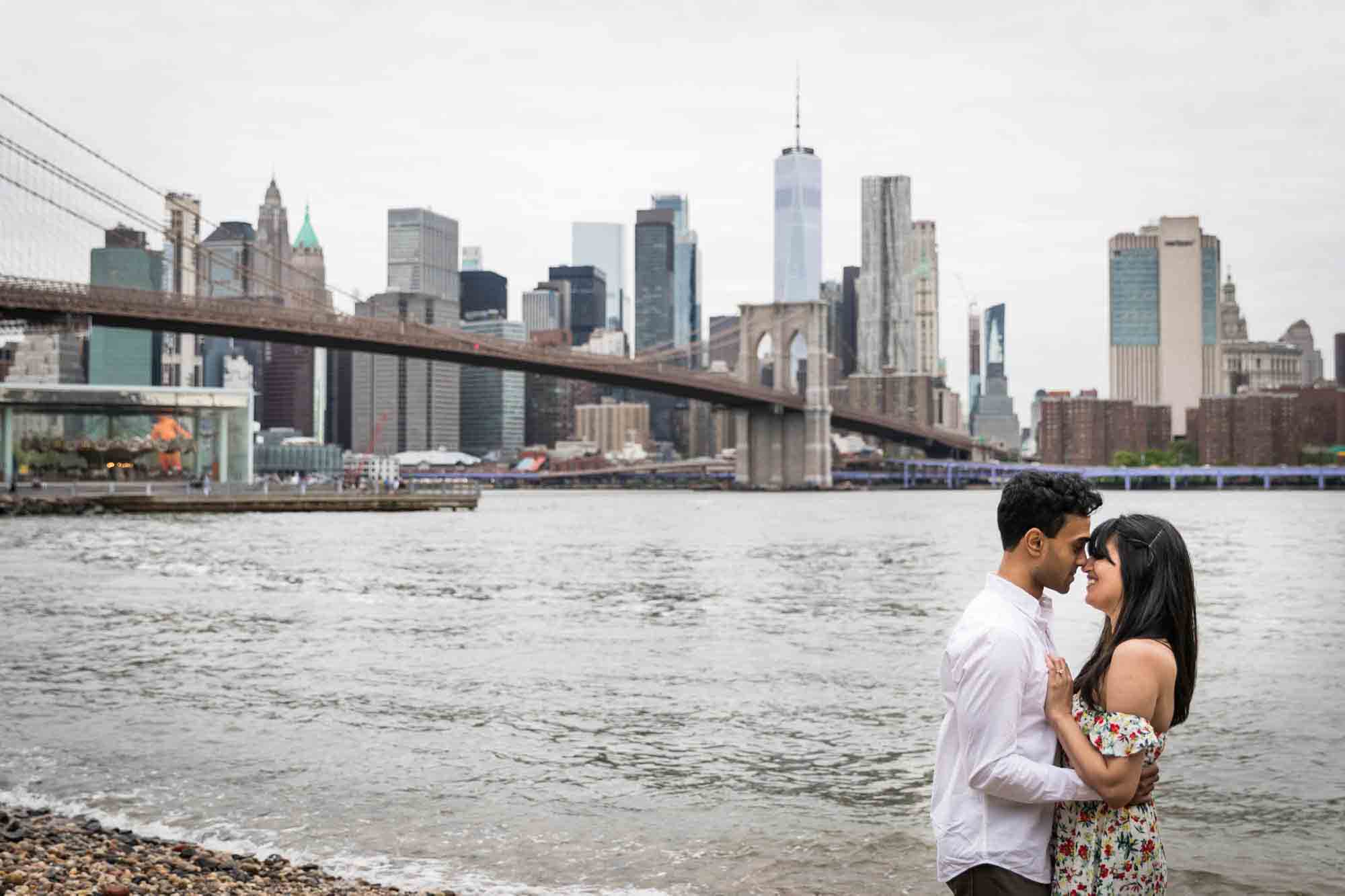 Couple in front of waterfront and NYC skyline at Brooklyn Bridge Park