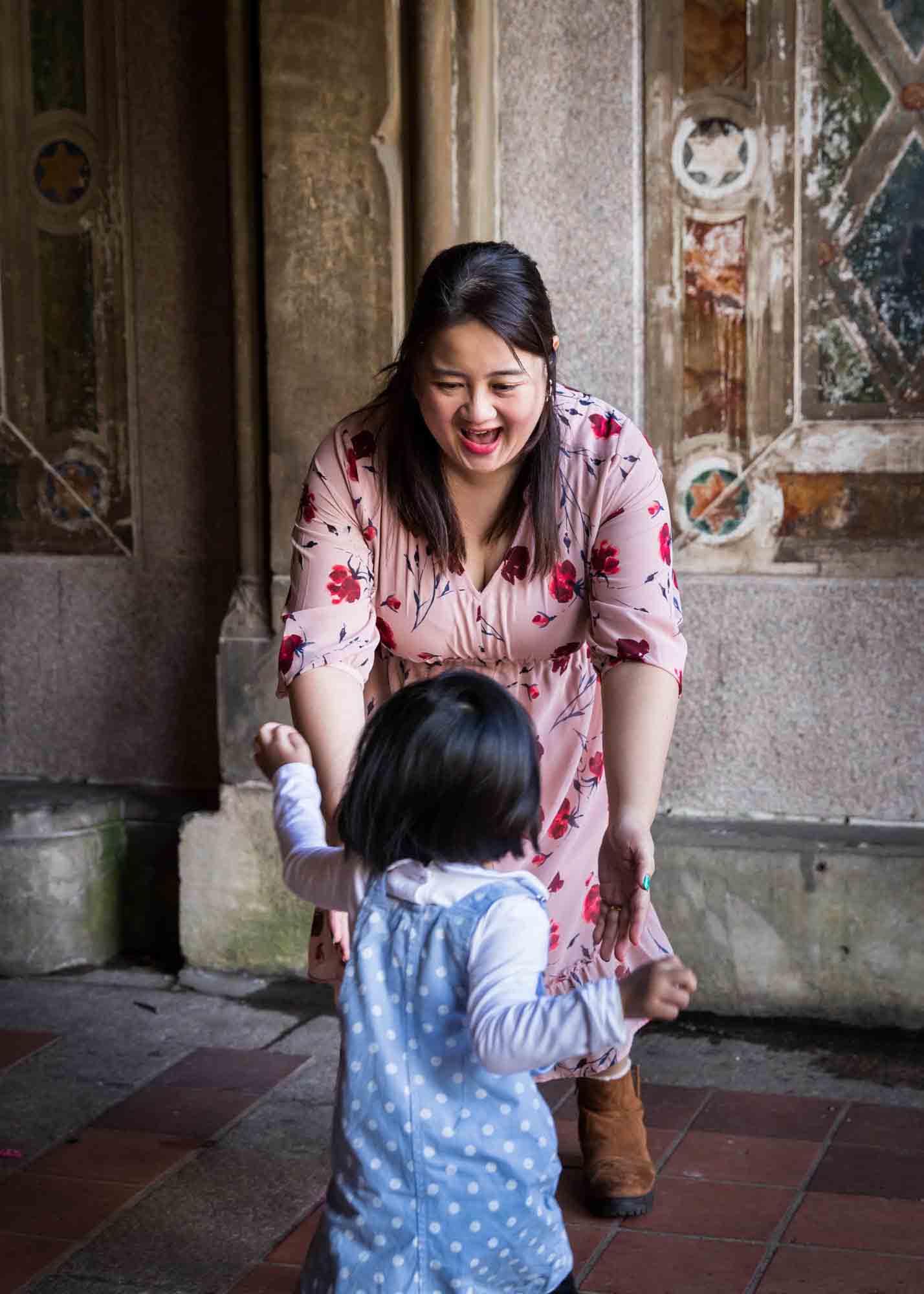 Little girl running to her mother under Bethesda Terrace during a Central Park family portrait