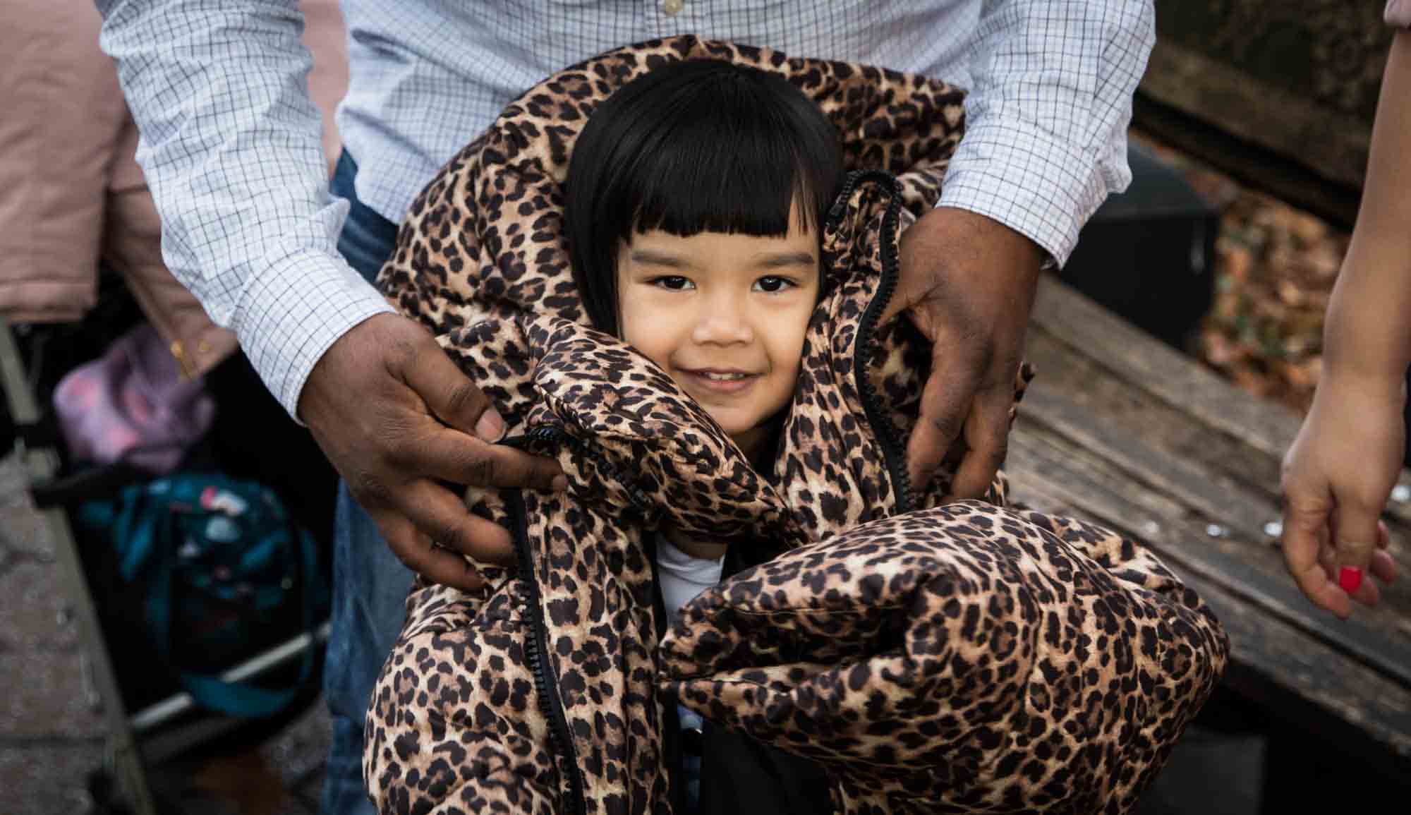 Little girl wrapped in leopard-print coat for an article on Central Park winter portrait tips