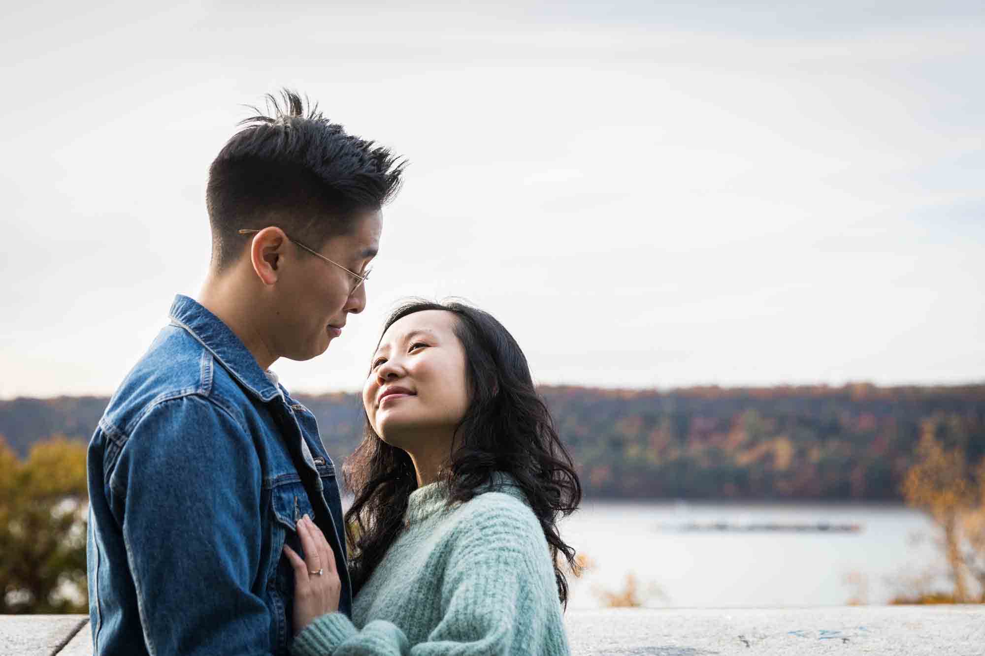Fort Tryon Park engagement photo of couple about to kiss in front of Hudson River