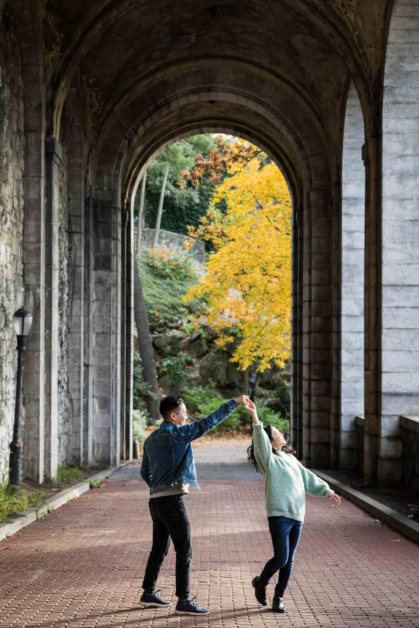 Fort Tryon Park engagement photos of couple dancing under Billings Arcade