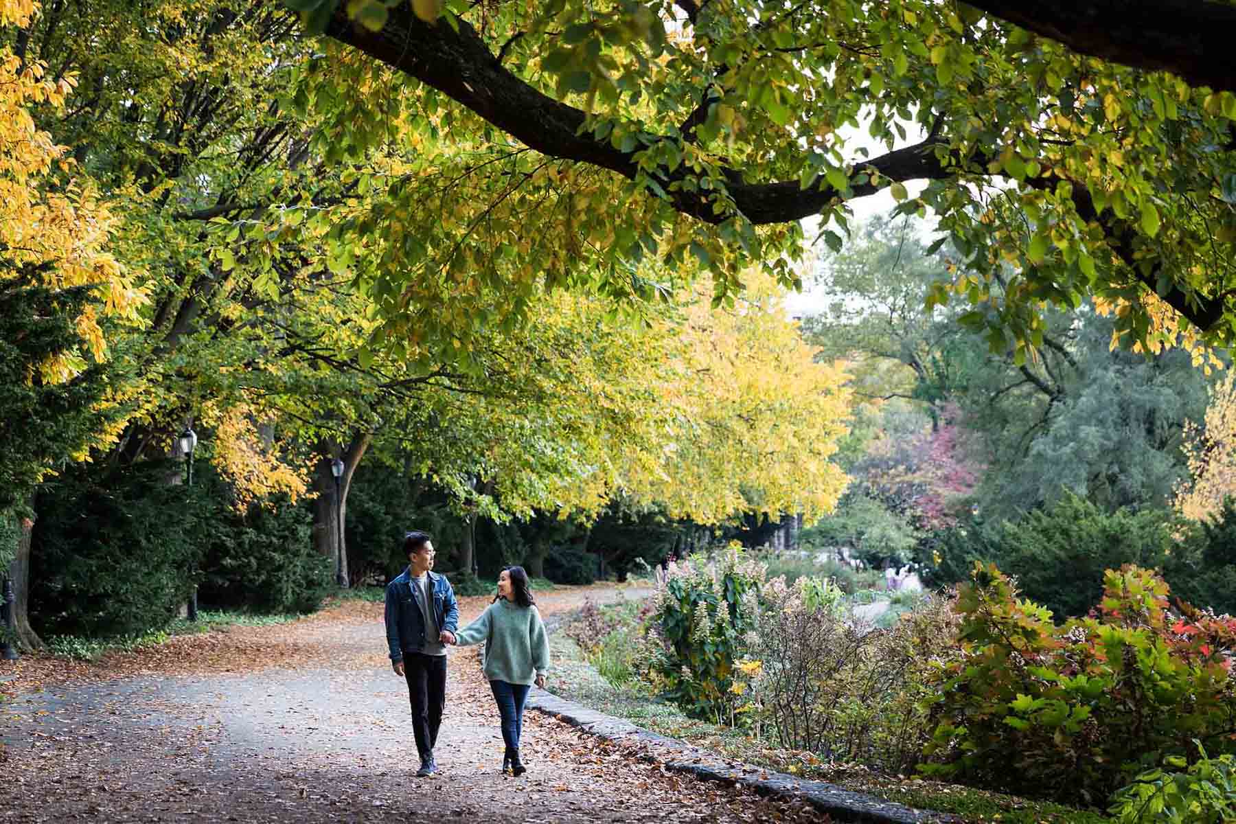 Fort Tryon Park engagement photos of couple walking on pathway in Heather Garden