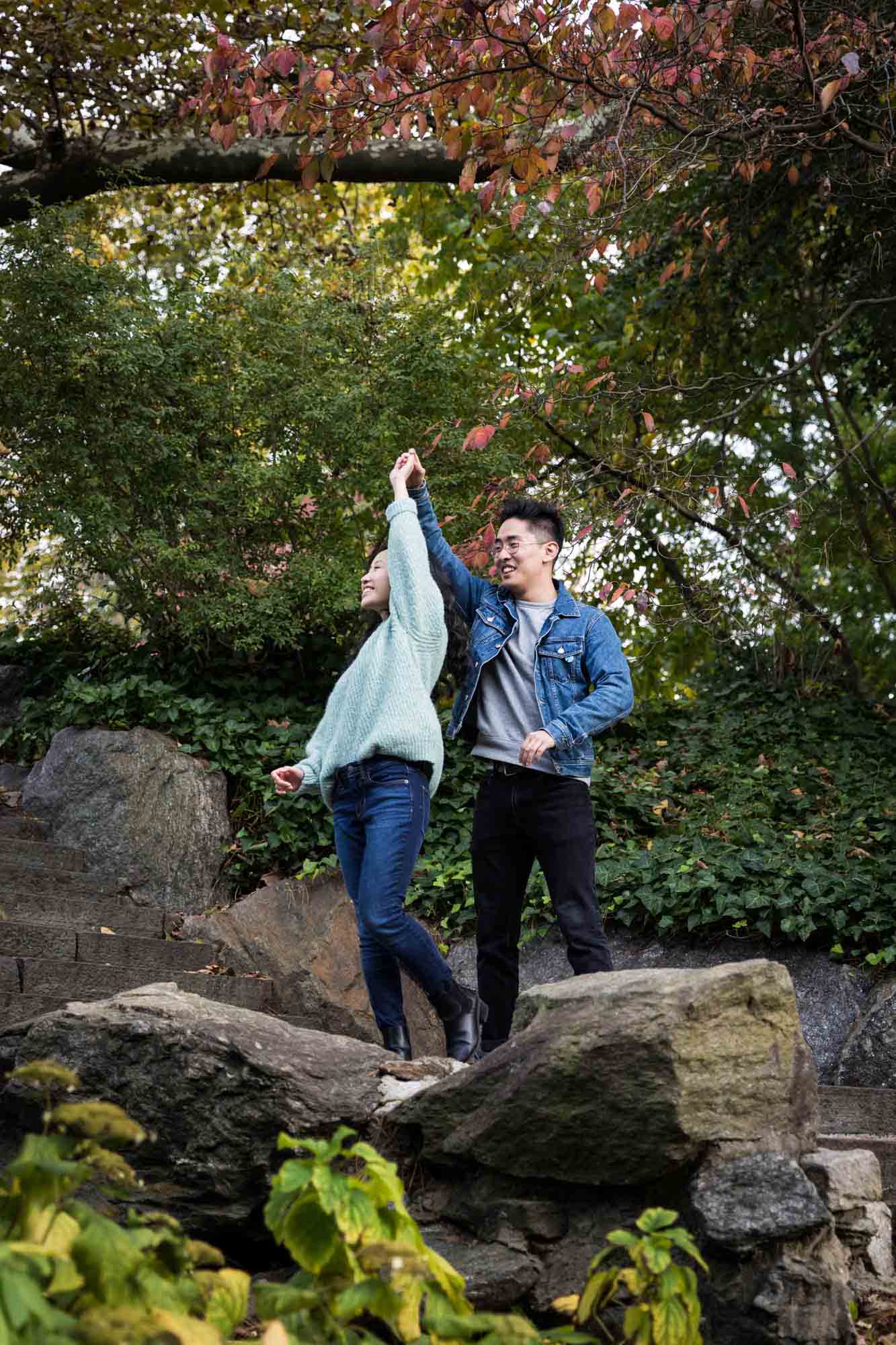 Fort Tryon Park engagement photo of couple dancing on stone stairway
