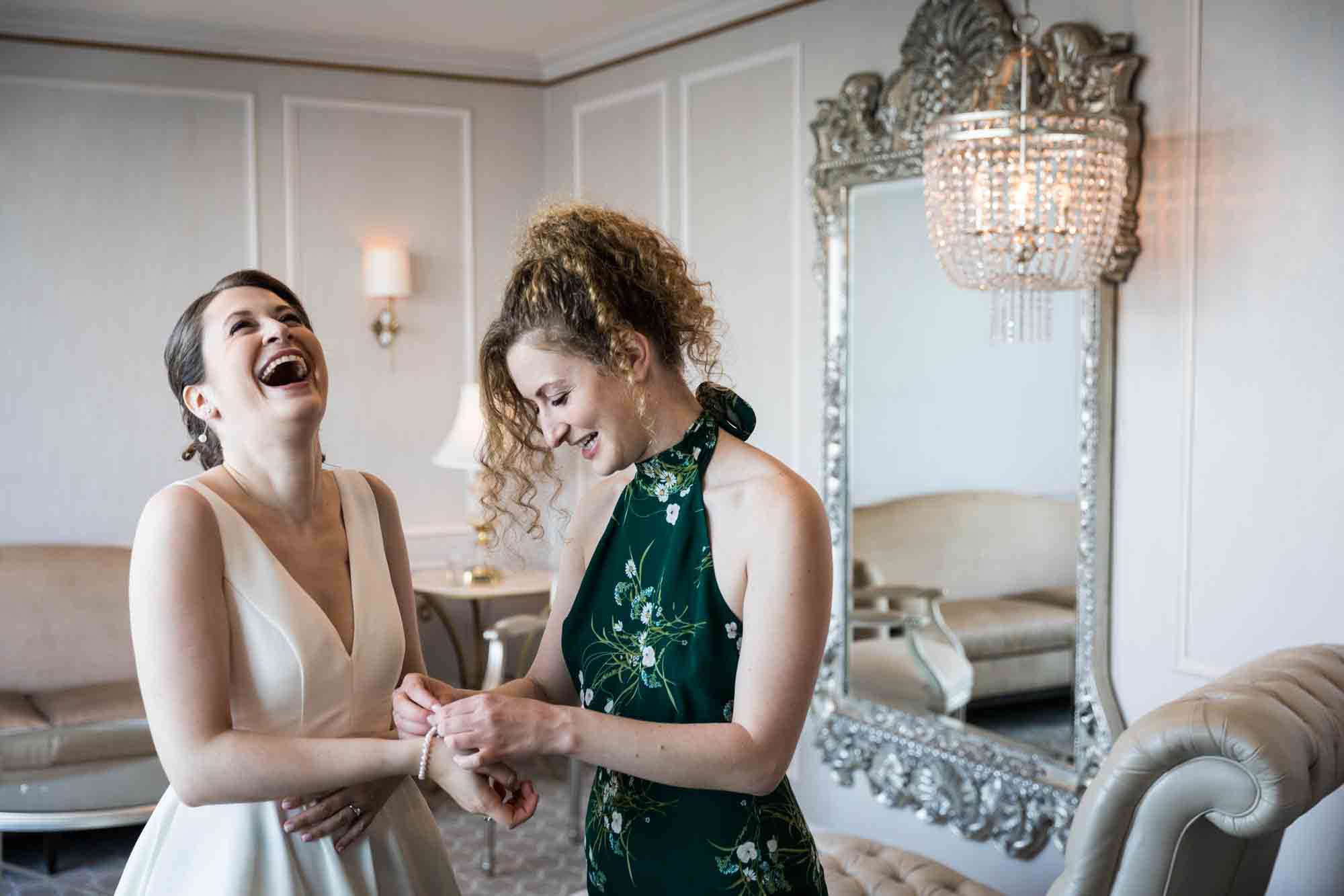 Glen Island Harbour Club wedding photos of bride laughing as bridesmaid puts on pearl bracelet