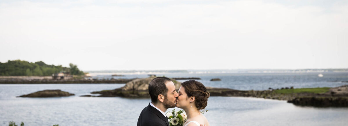 Glen Island Harbour Club wedding photos of bride and groom kissing in front of Long Island Sound