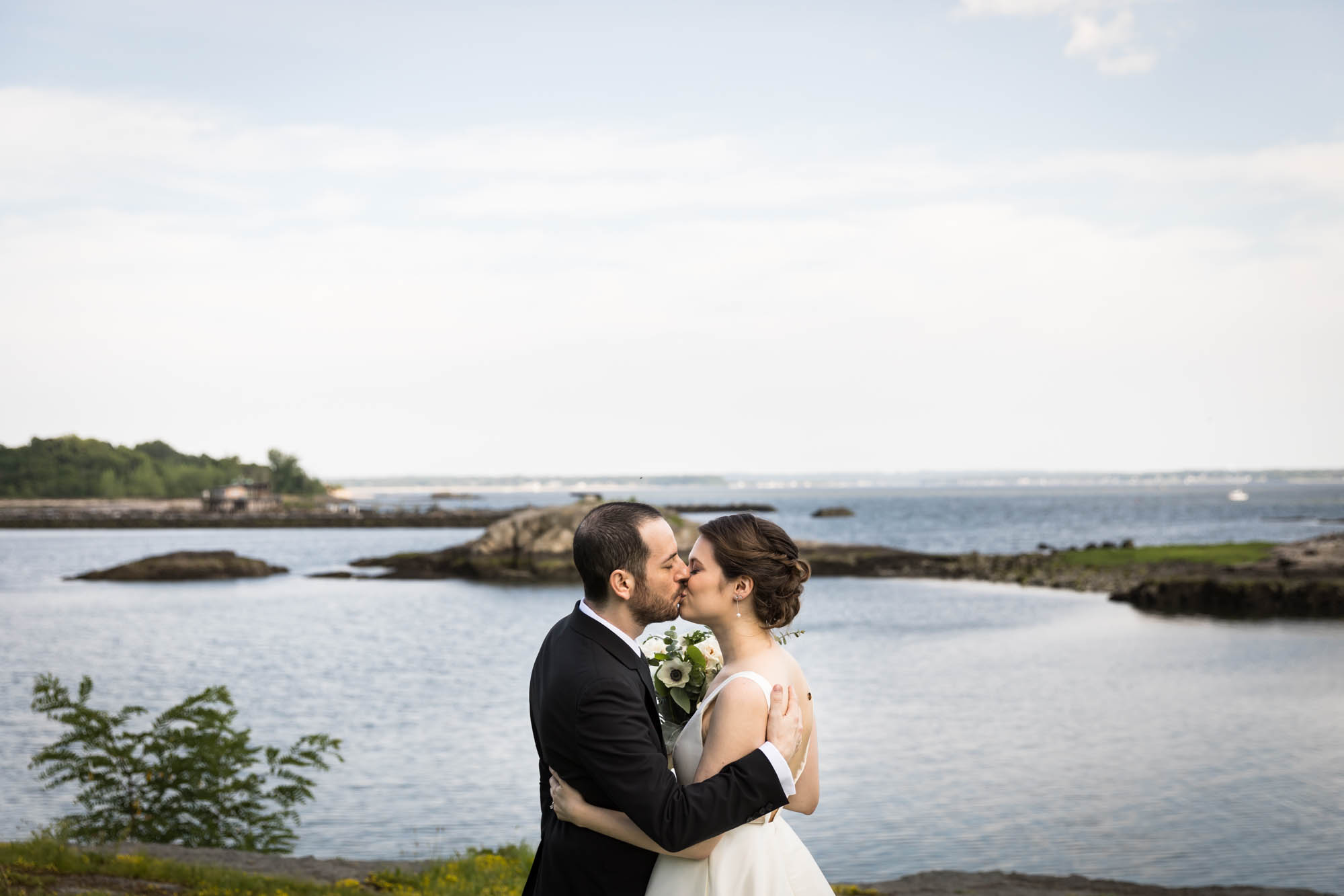 Glen Island Harbour Club wedding photos of bride and groom kissing in front of Long Island Sound