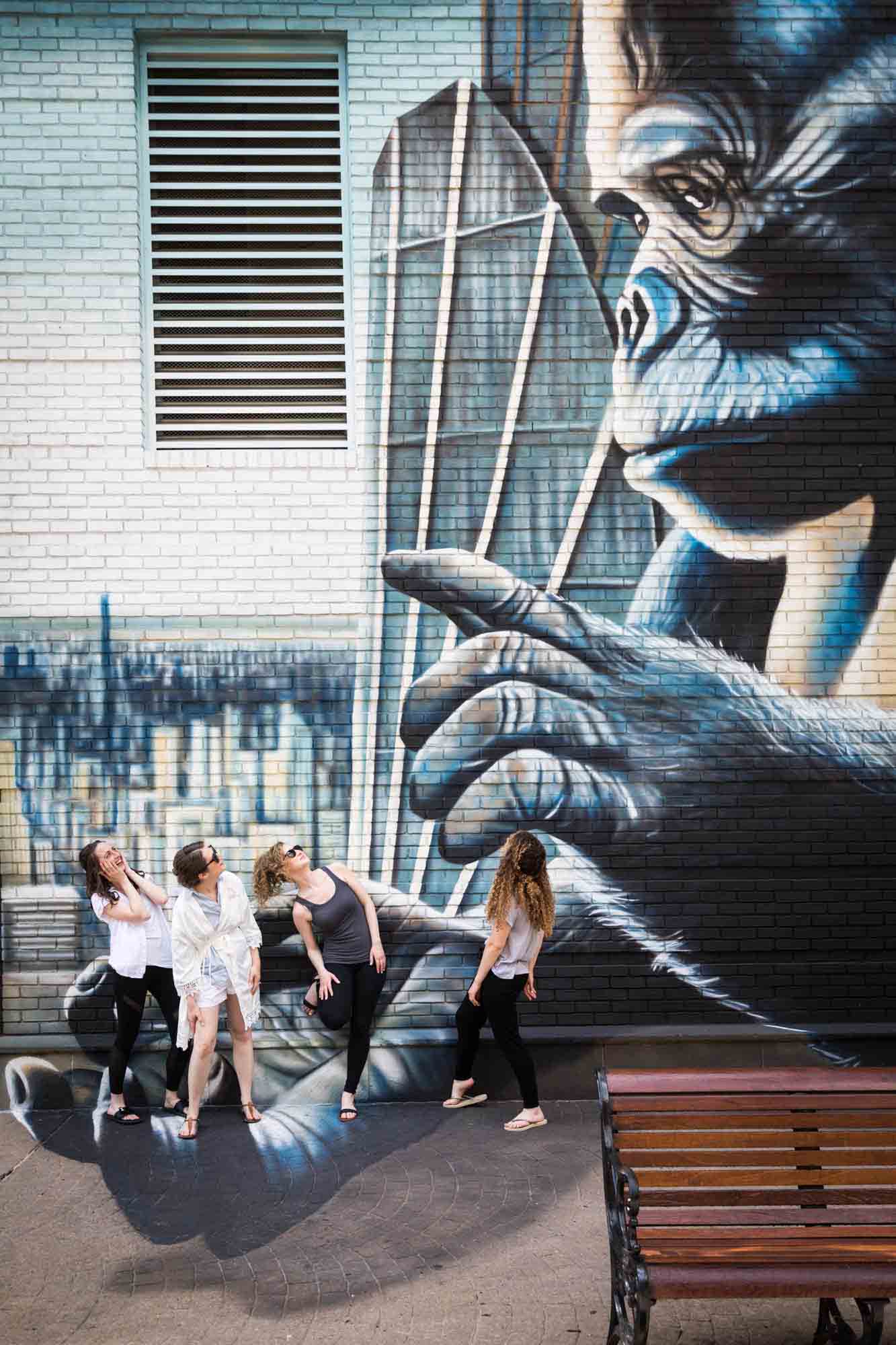 Bride and bridesmaids standing in front of King Kong wall mural in New Rochelle
