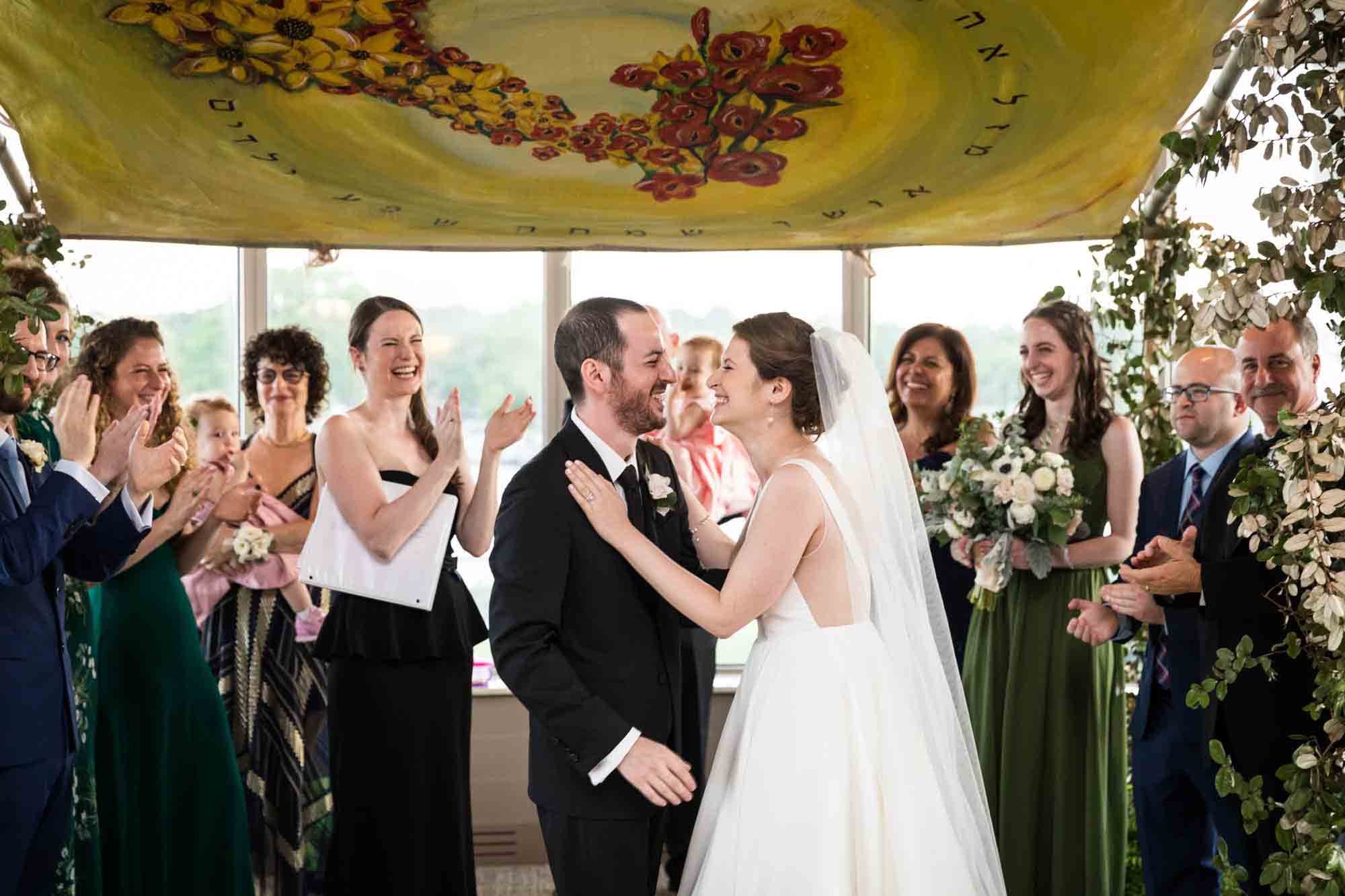 Bride and groom laughing under chuppah at a Glen Island Harbour Club wedding