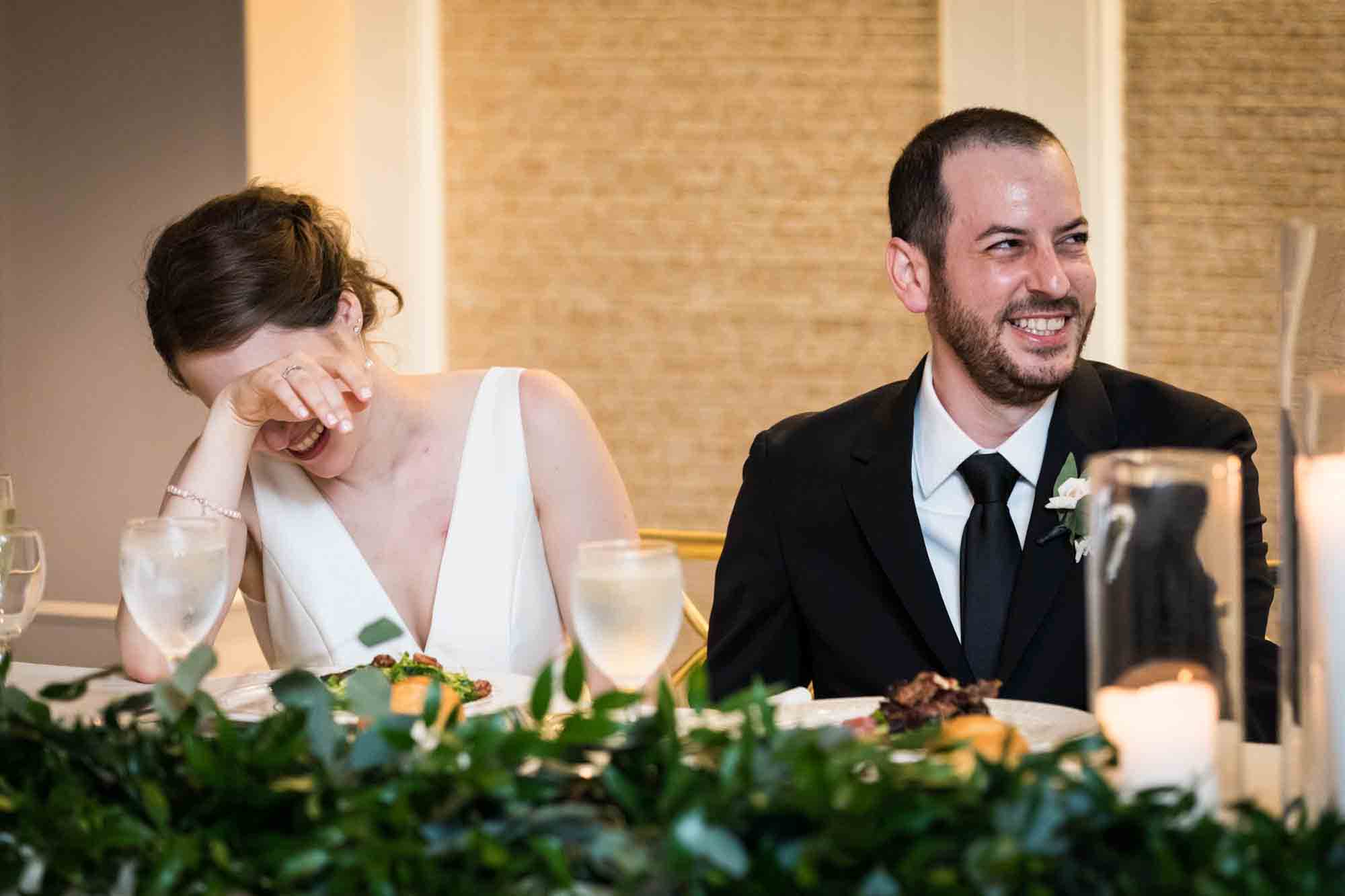 Bride and groom laughing during speech at a Glen Island Harbour Club wedding