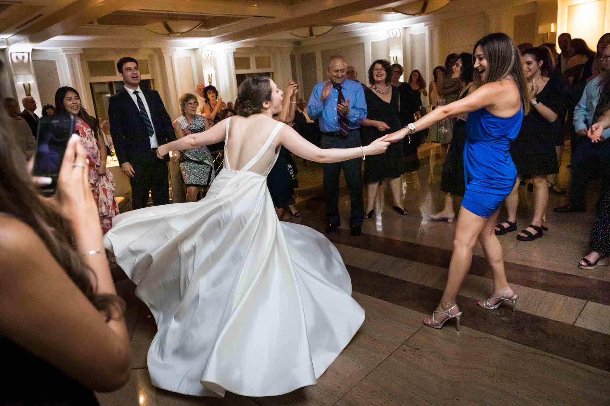 Woman in blue dress dancing with bride at a Glen Island Harbour Club wedding