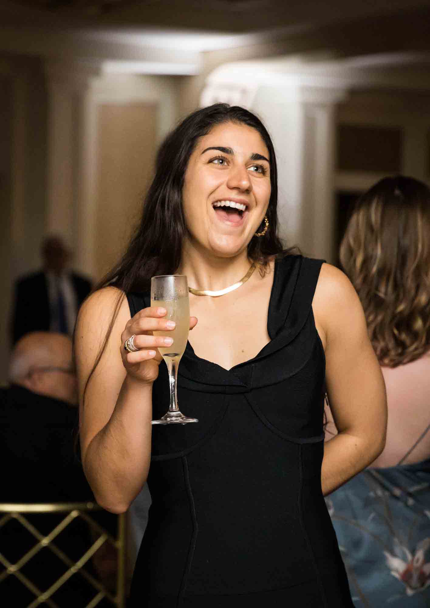 Woman in black dress holding glass of champagne at a Glen Island Harbour Club wedding