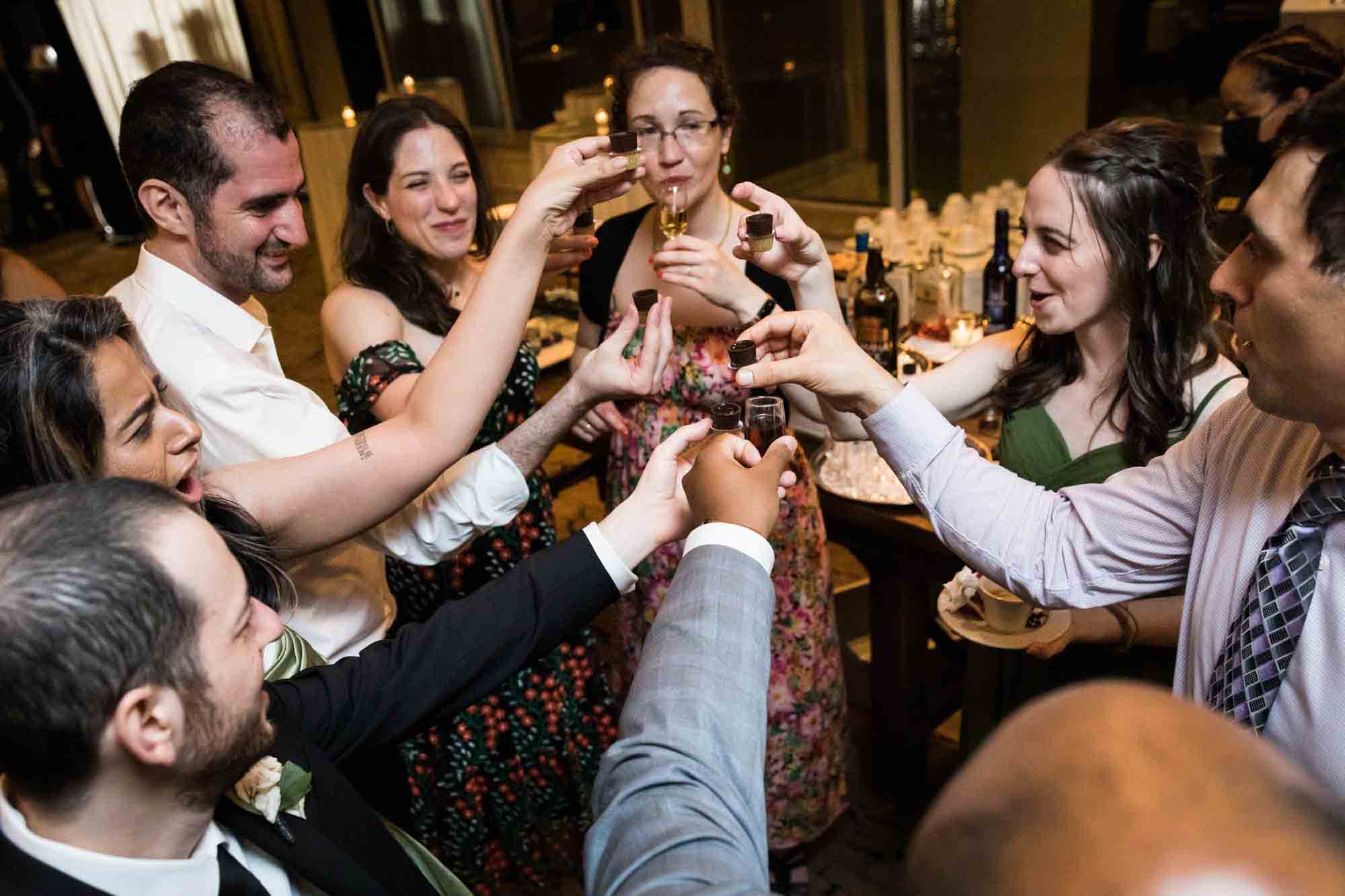 Guests making a toast with dessert liqueur at a Glen Island Harbour Club wedding