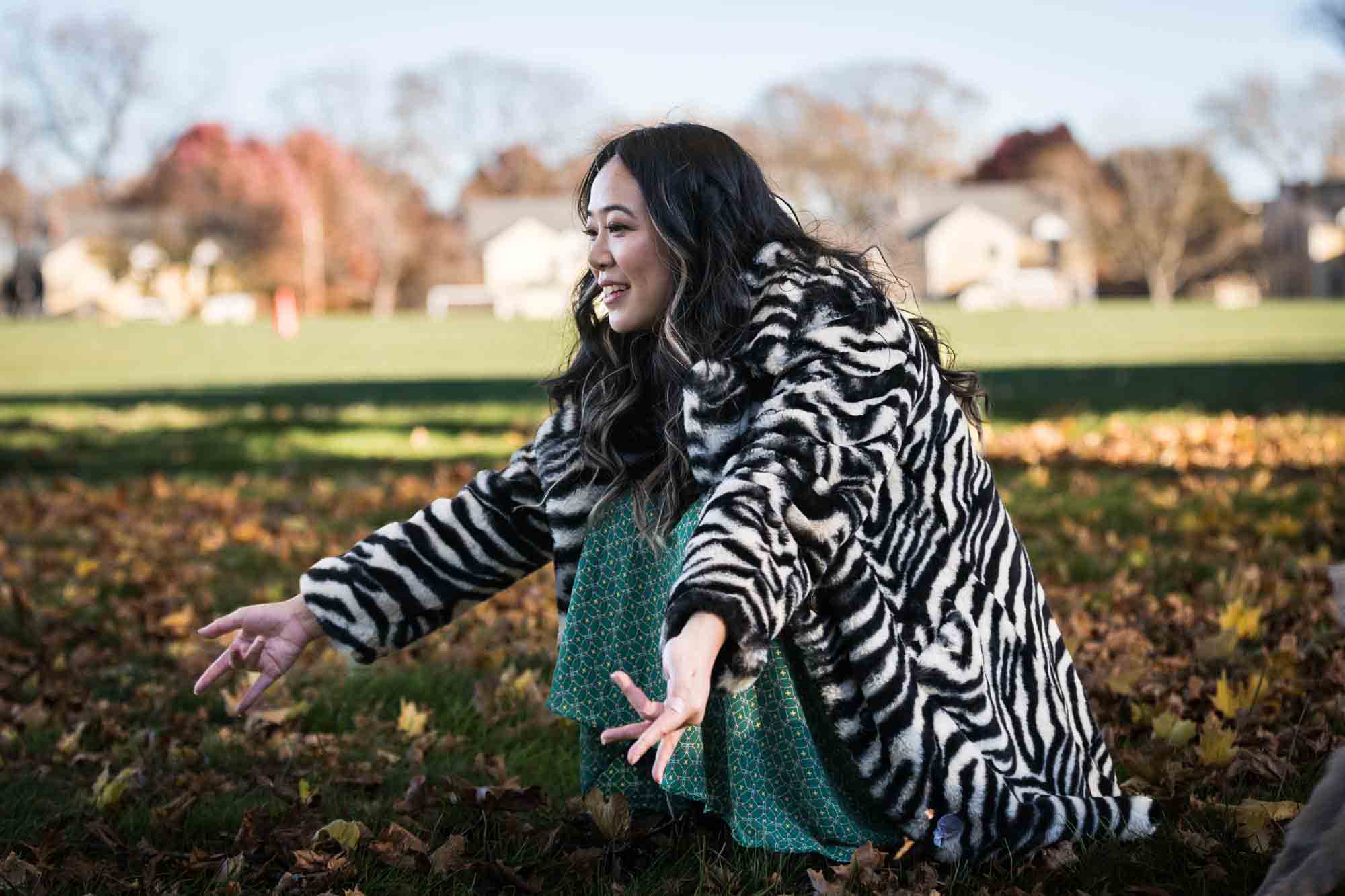 Woman squatting down on grown holding out hands to dogs on Governors Island