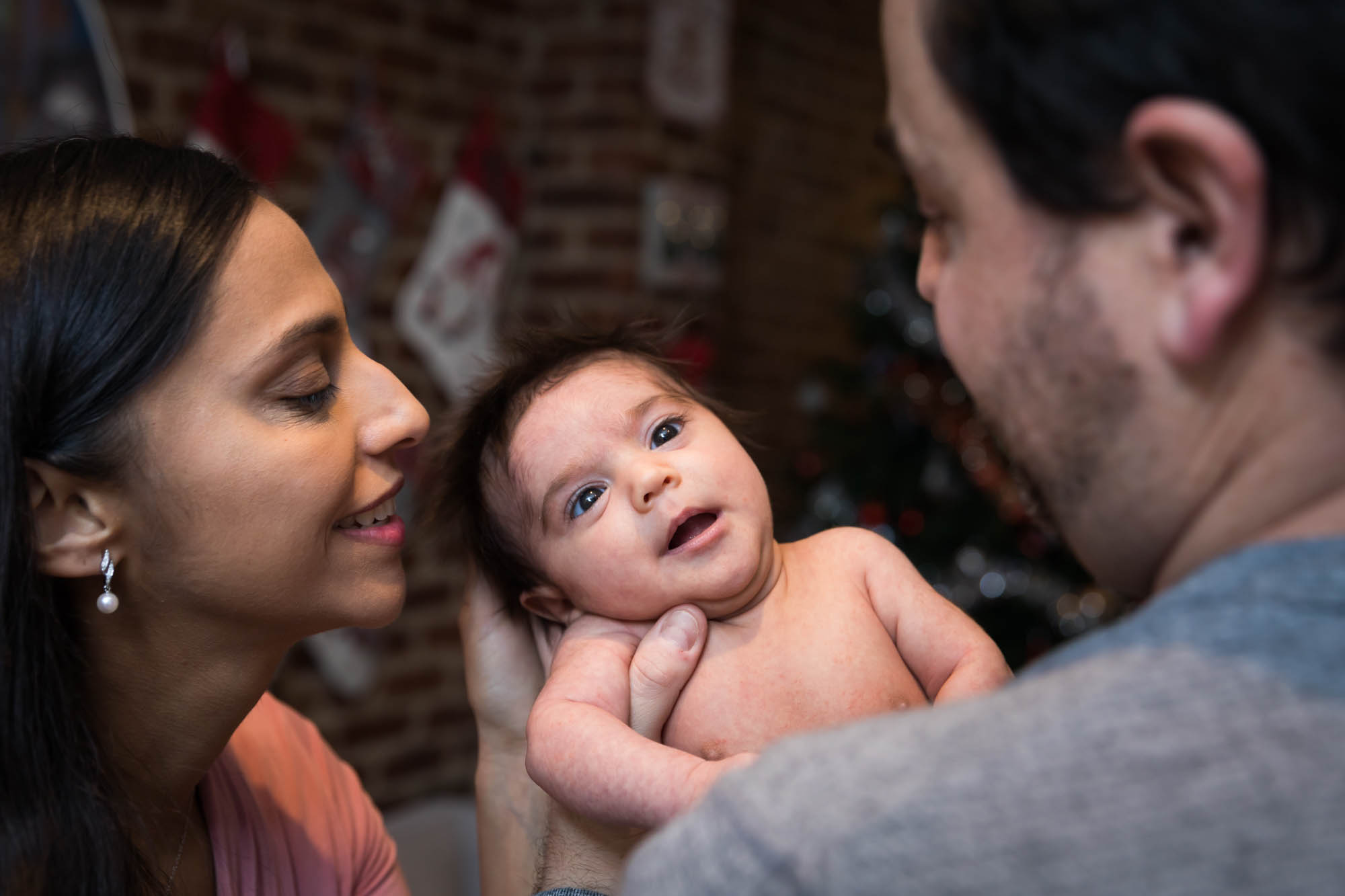 Parents holding a newborn baby during a Christmas-themed newborn photo shoot in NYC