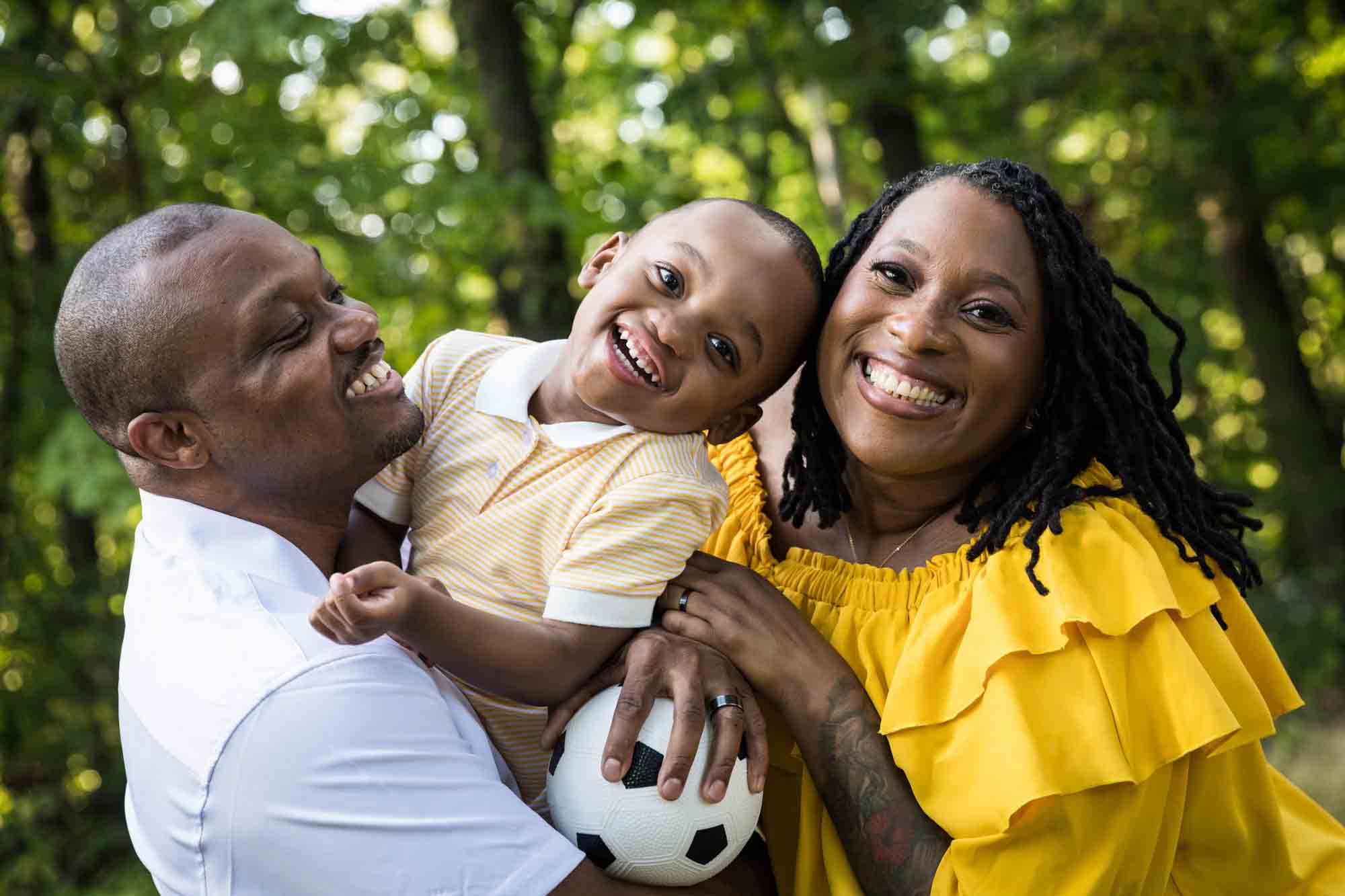 African American family laughing in park for an article advertising family portrait gift certificates