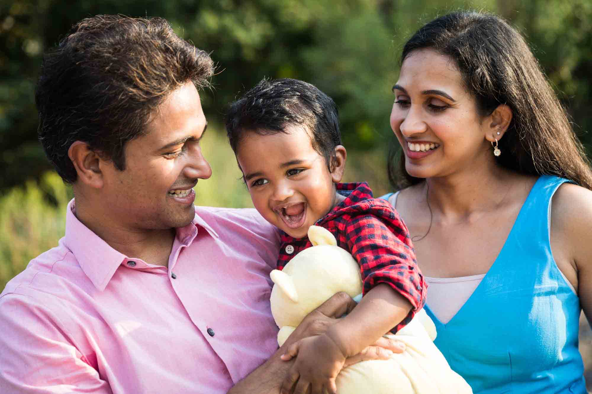 Indian American family laughing in park for an article advertising family portrait gift certificates