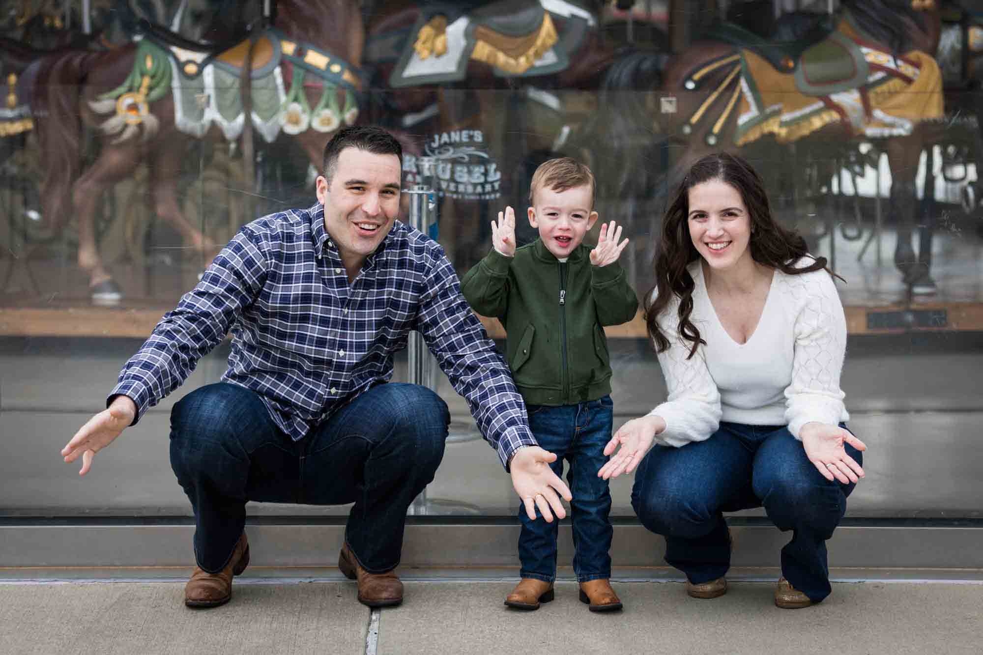 Parents and son playing peek-a-book in Brooklyn Bridge Park for an article advertising family portrait gift certificates