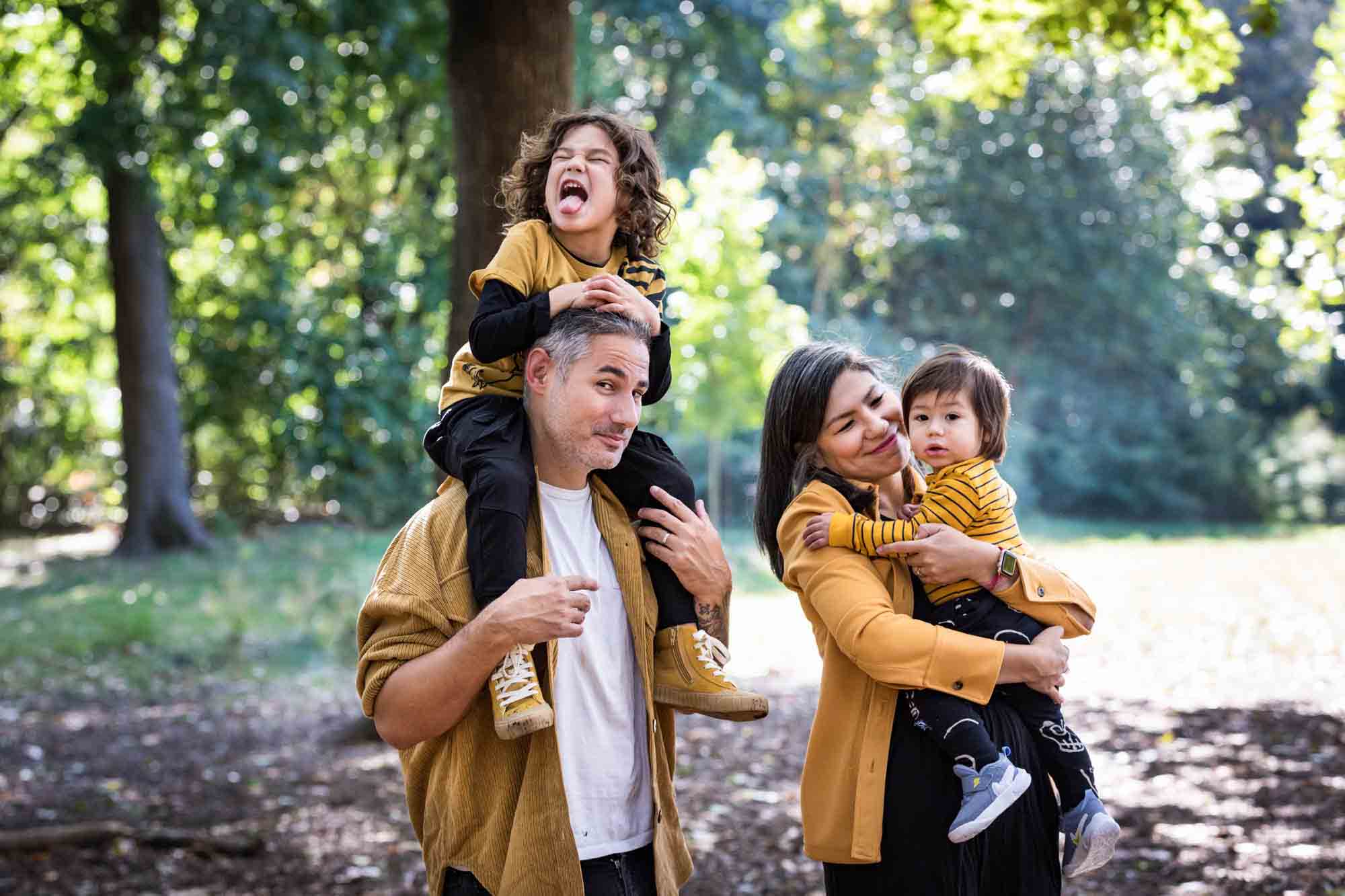 Family wearing yellow holding two boys in Prospect Park