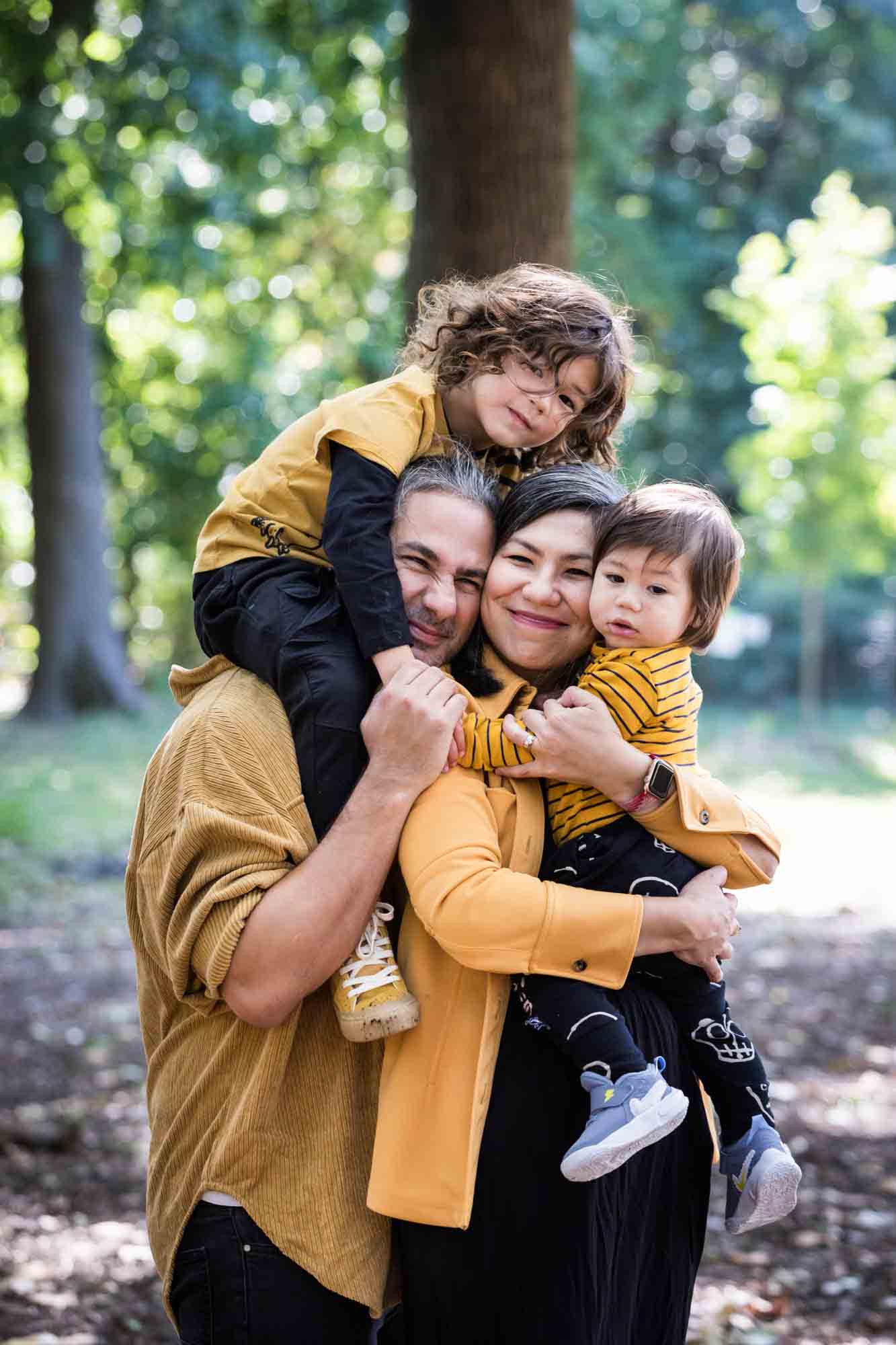 Parents and two young boys all hugging in Prospect Park