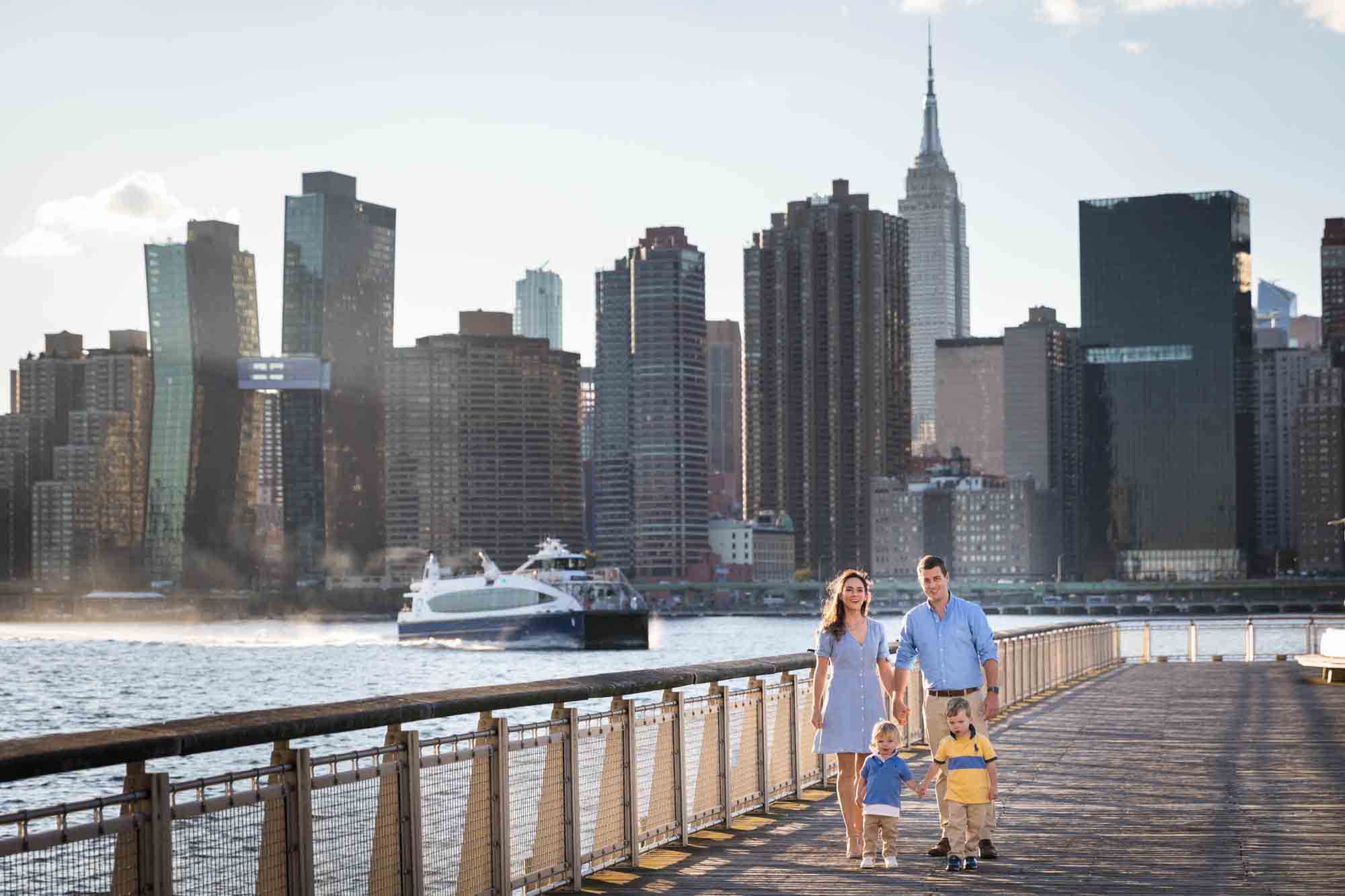 Parents and two young boys walking along dock in Gantry Plaza State Park