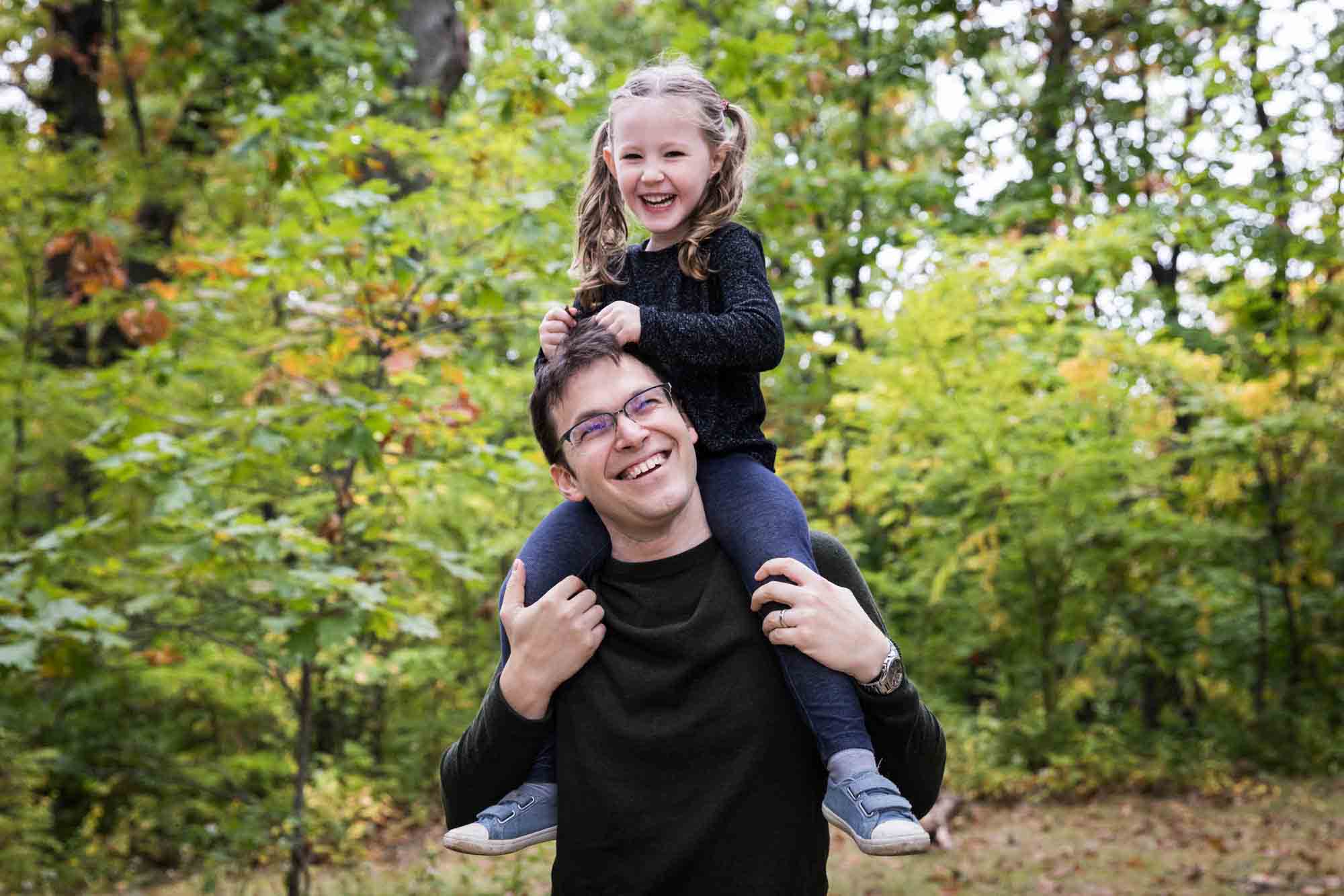 Father with daughter on his shoulders clowning around in Forest Park