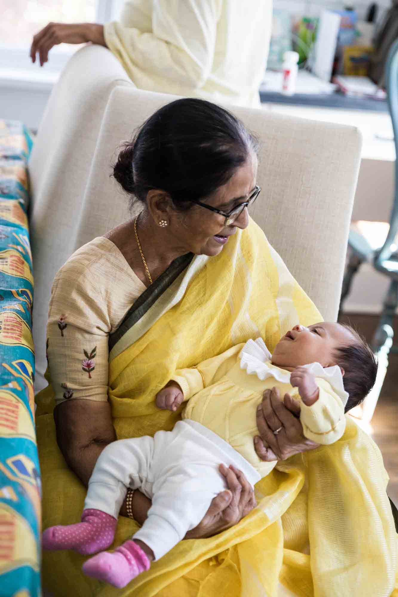 Indian grandmother looking down on new grandbaby for an article advertising family portrait gift certificates