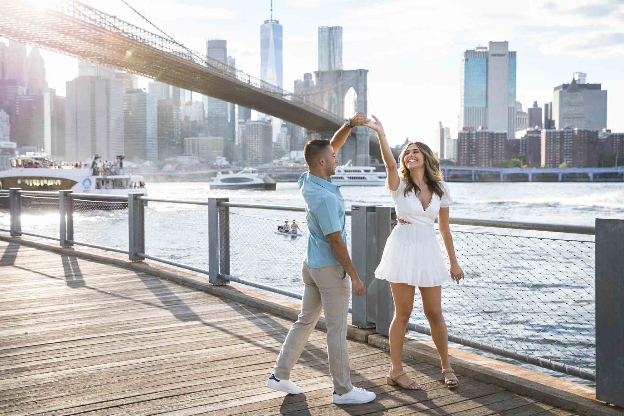 Couple dancing on boardwalk during a surprise proposal in Brooklyn Bridge Park