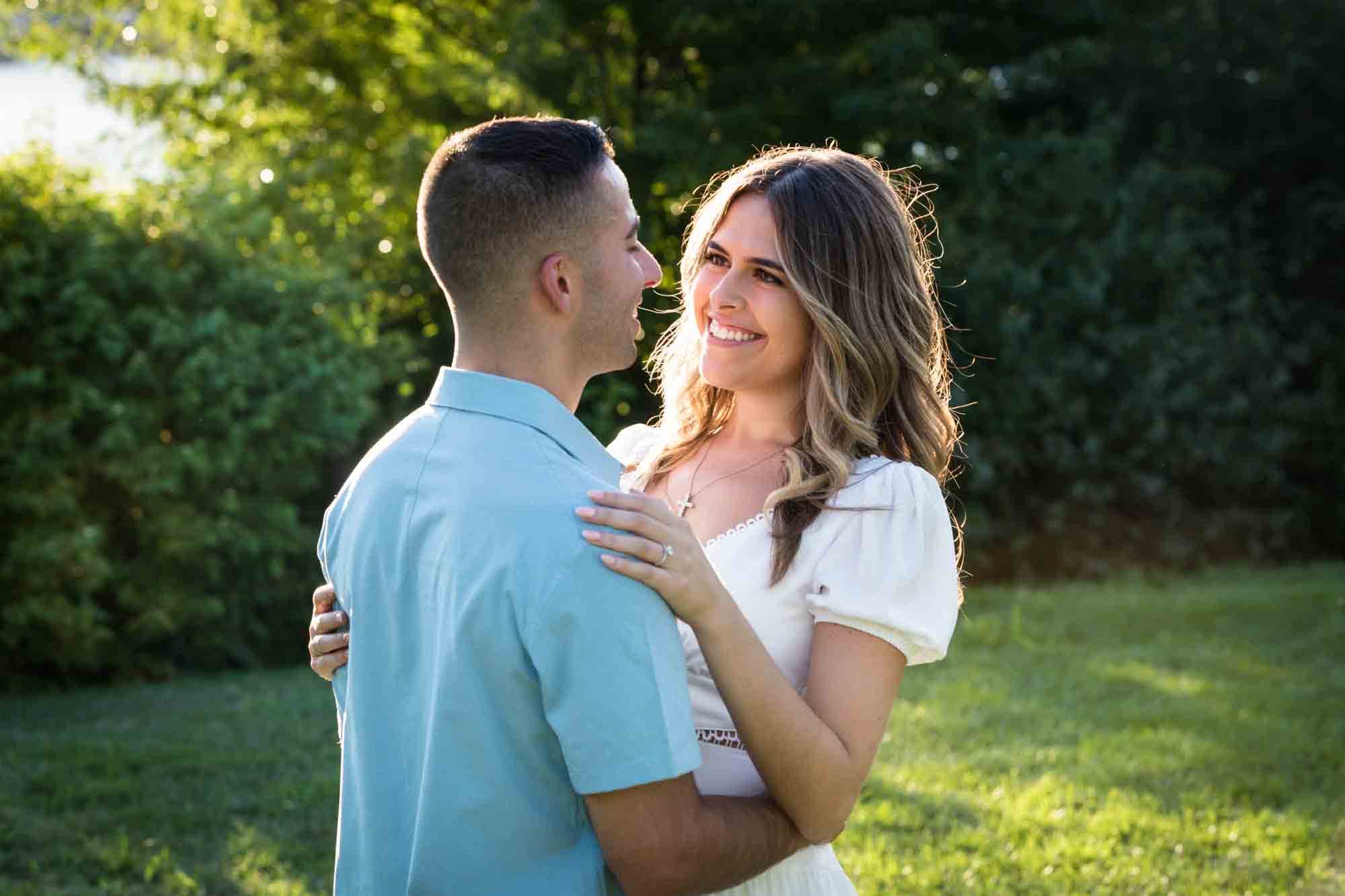 Couple hugging in grass in Brooklyn Bridge Park