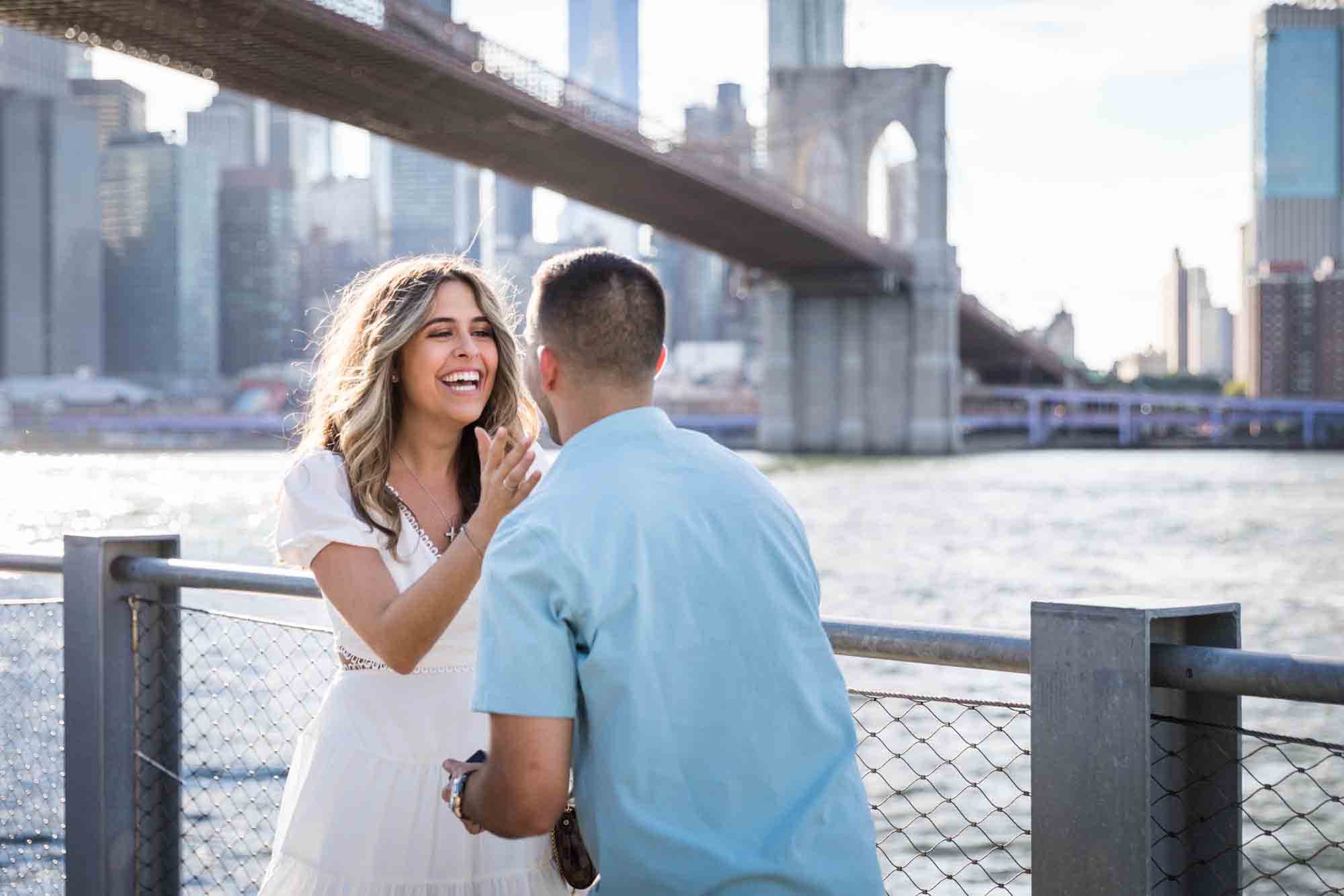 Woman grabbing man's shirt during a Brooklyn Bridge Park surprise proposal