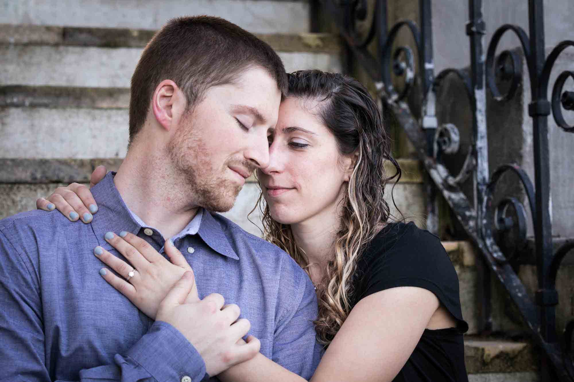 Couple cuddling on stone steps at a Vanderbilt Museum engagement photo shoot