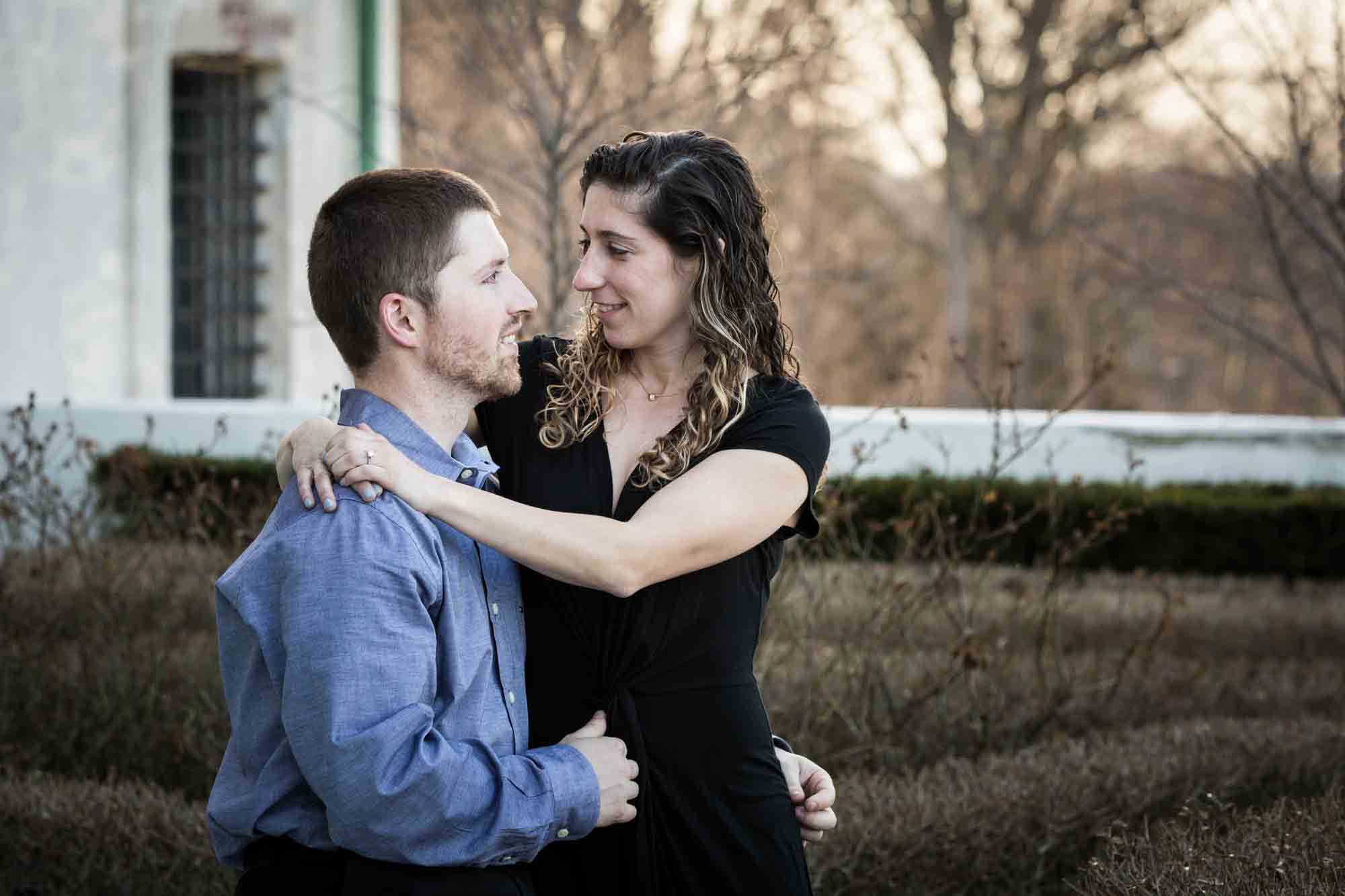 Couple hugging in back garden at a Vanderbilt Museum engagement photo shoot