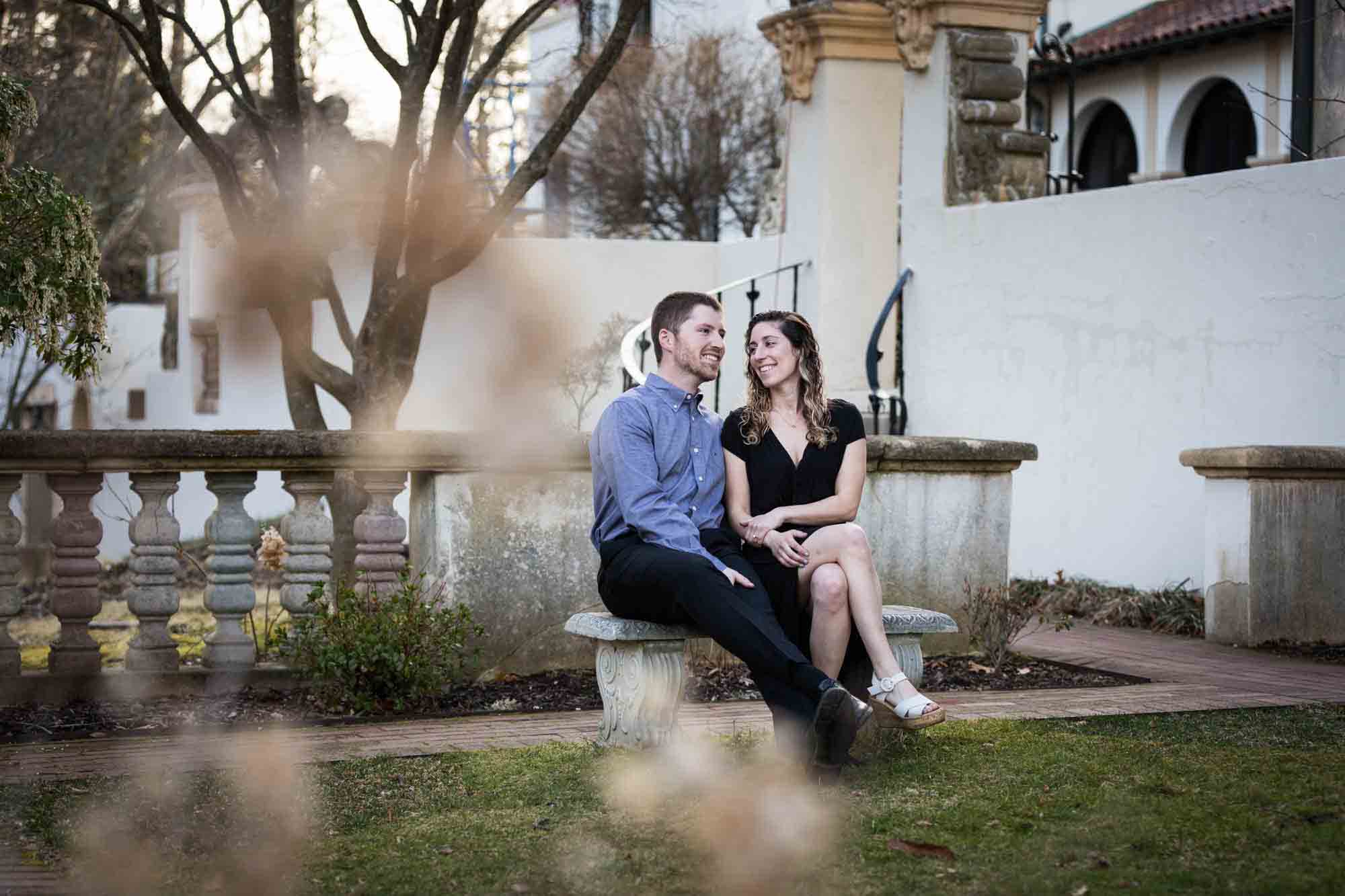 Vanderbilt Museum engagement photos of couple sitting on bench in garden