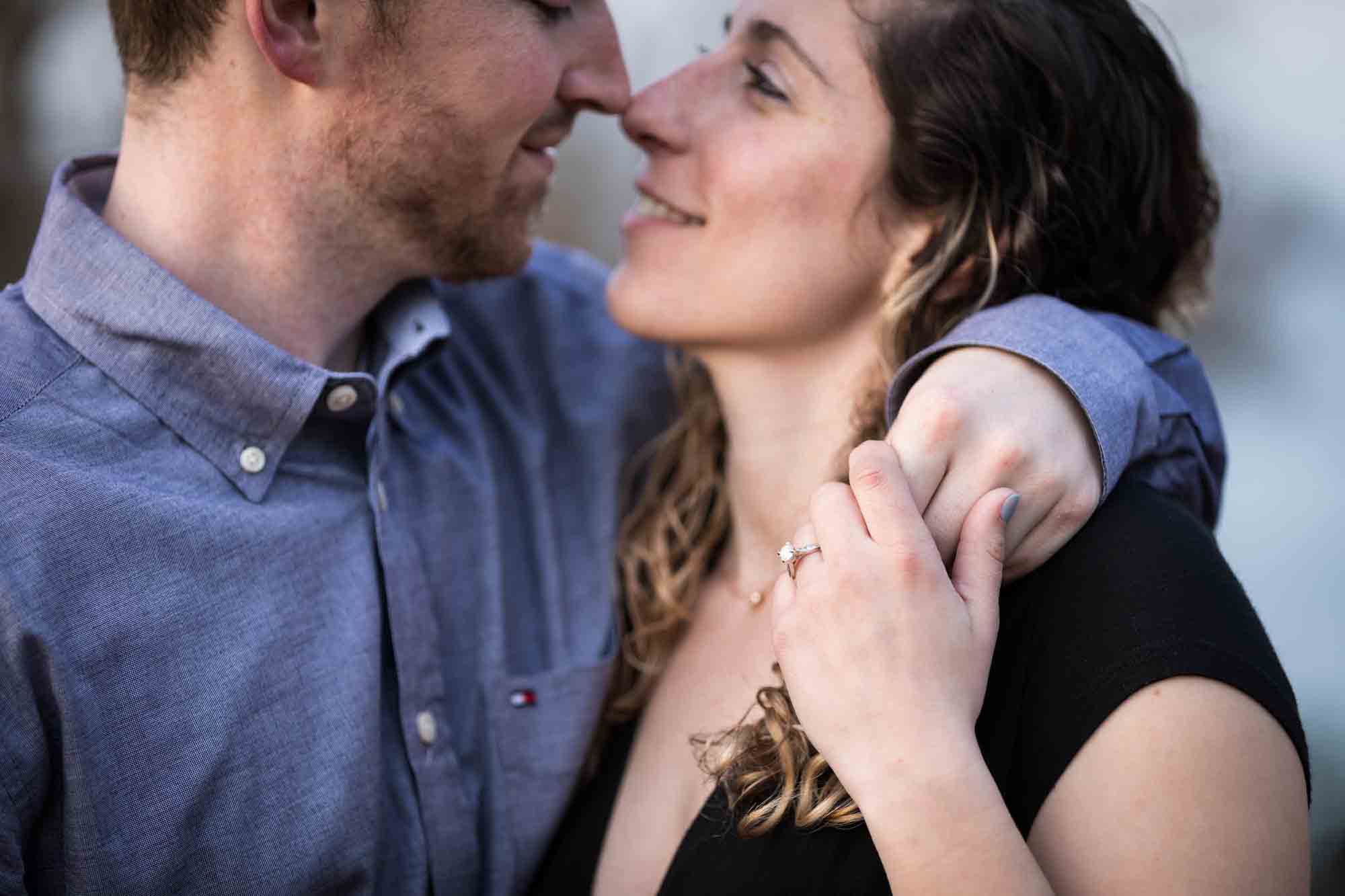 Vanderbilt Museum engagement photos of couple about to kiss and woman holding man's hand on her shoulder