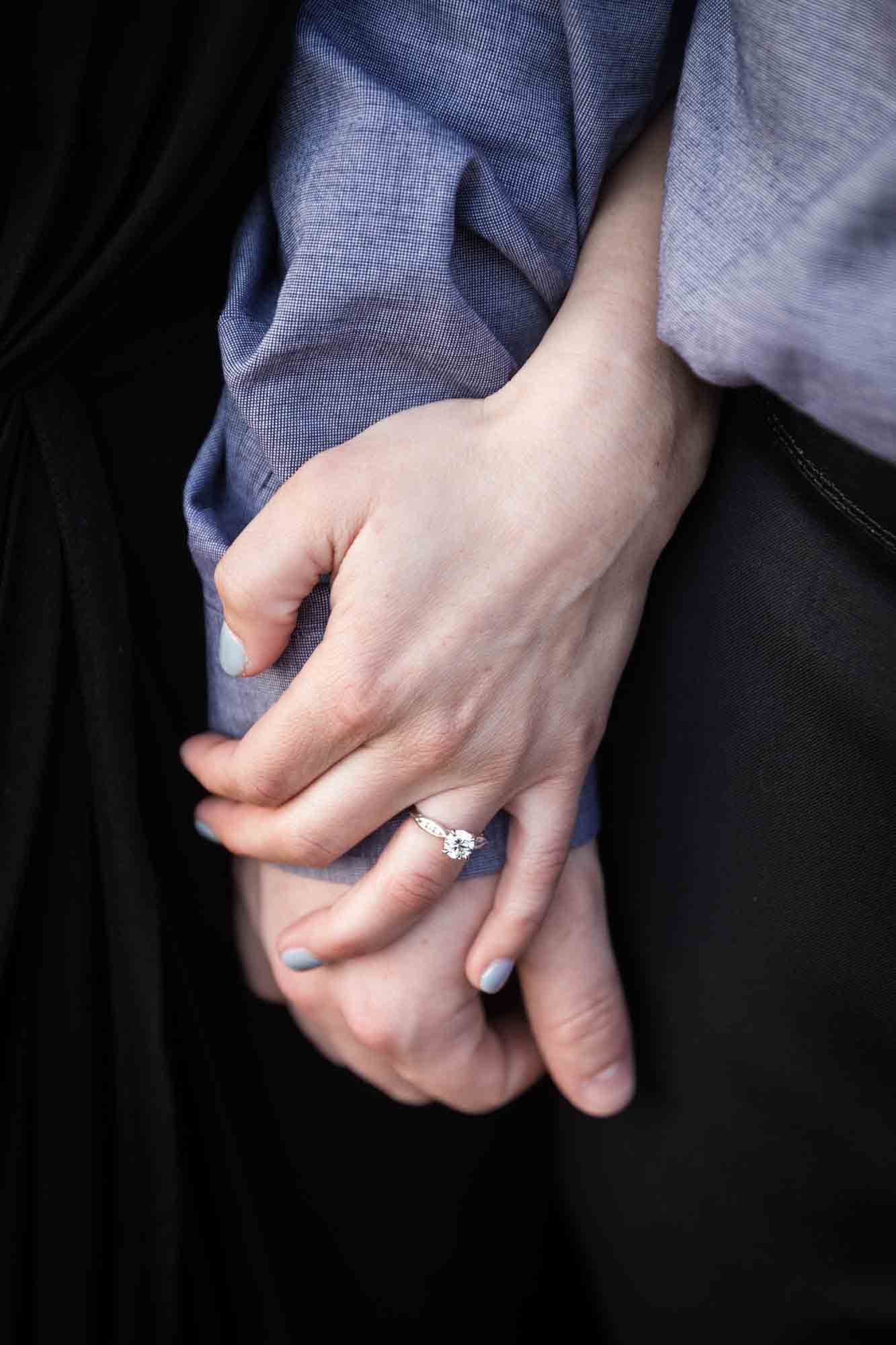 Vanderbilt Museum engagement photos of couple's hands with woman's finger showing engagement ring