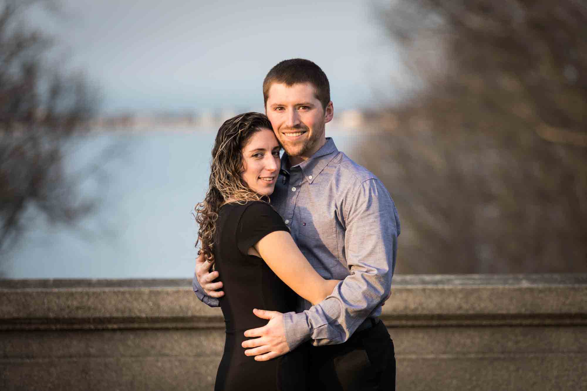 Vanderbilt Museum engagement photos of couple hugging against stone railing