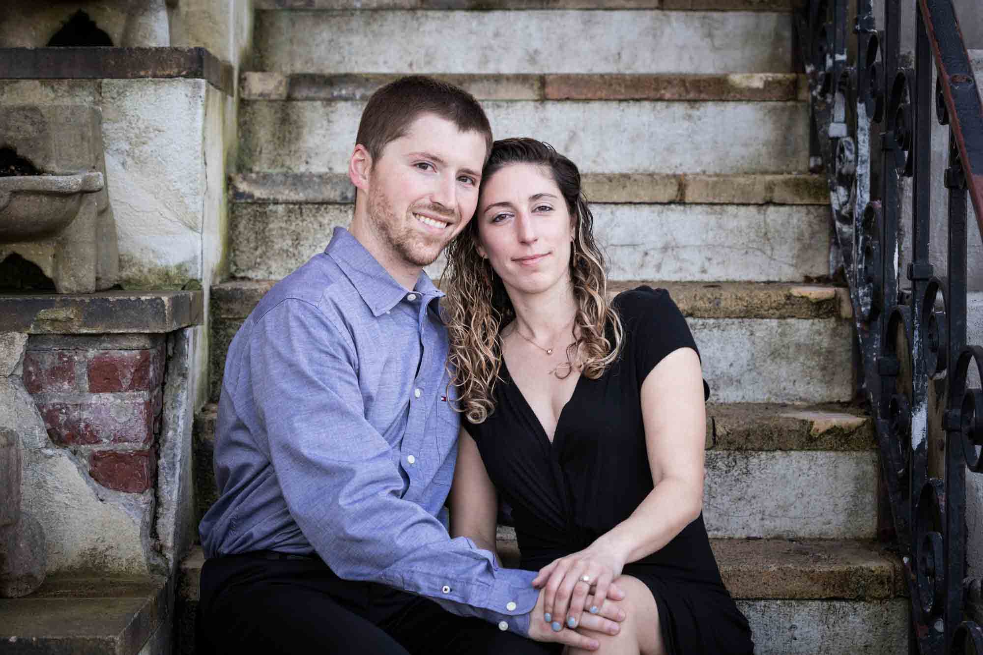 Couple sitting on stone stairs during a Vanderbilt Museum engagement photo shoot